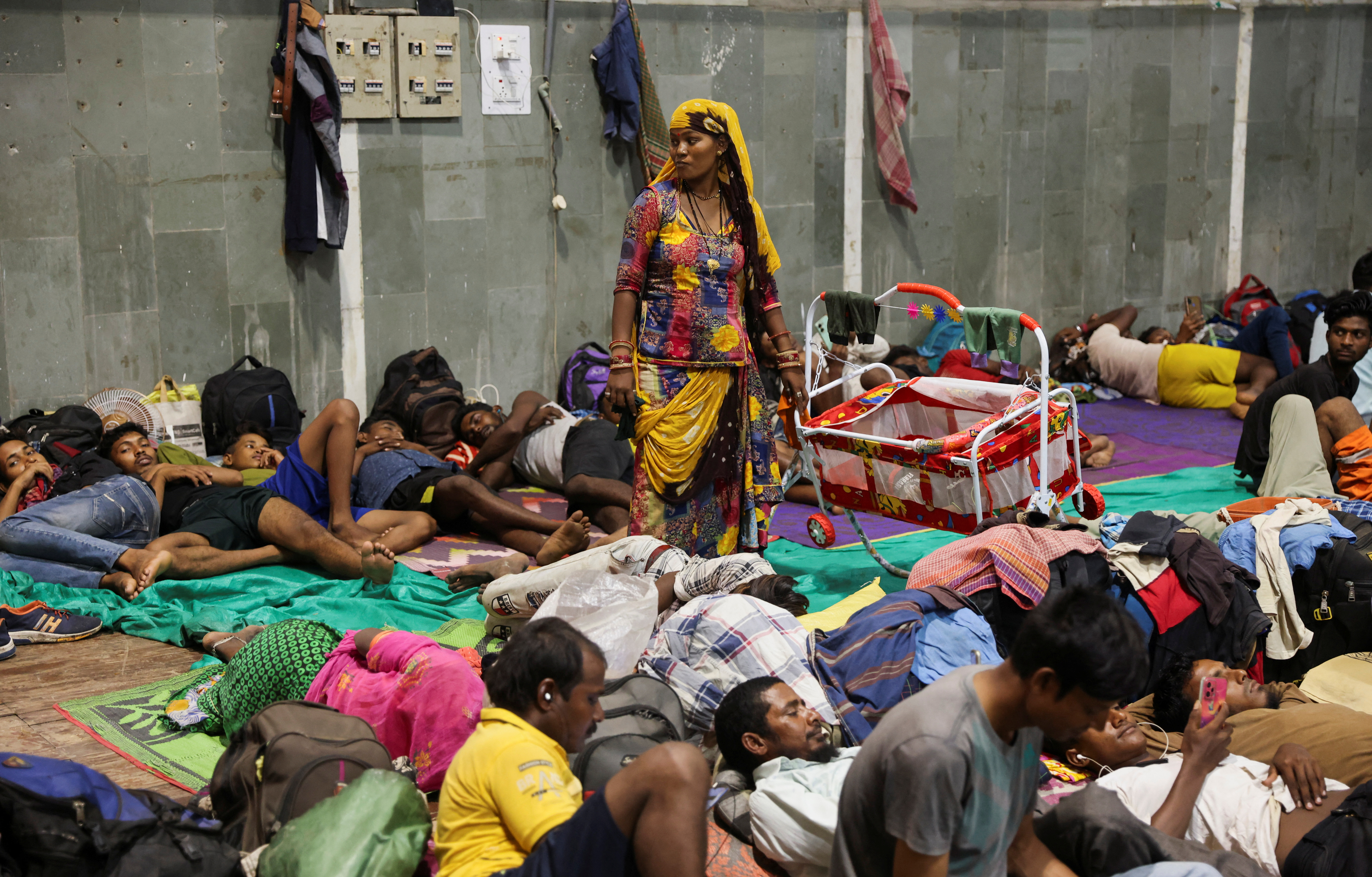 Laxmi Kumar pushes a cradle carrying her three year old son Arvind at a temporary shelter for people evacuated from Kandla port, before the arrival of cyclone Biparjoy, in Gandhidham, in the western state of Gujarat,