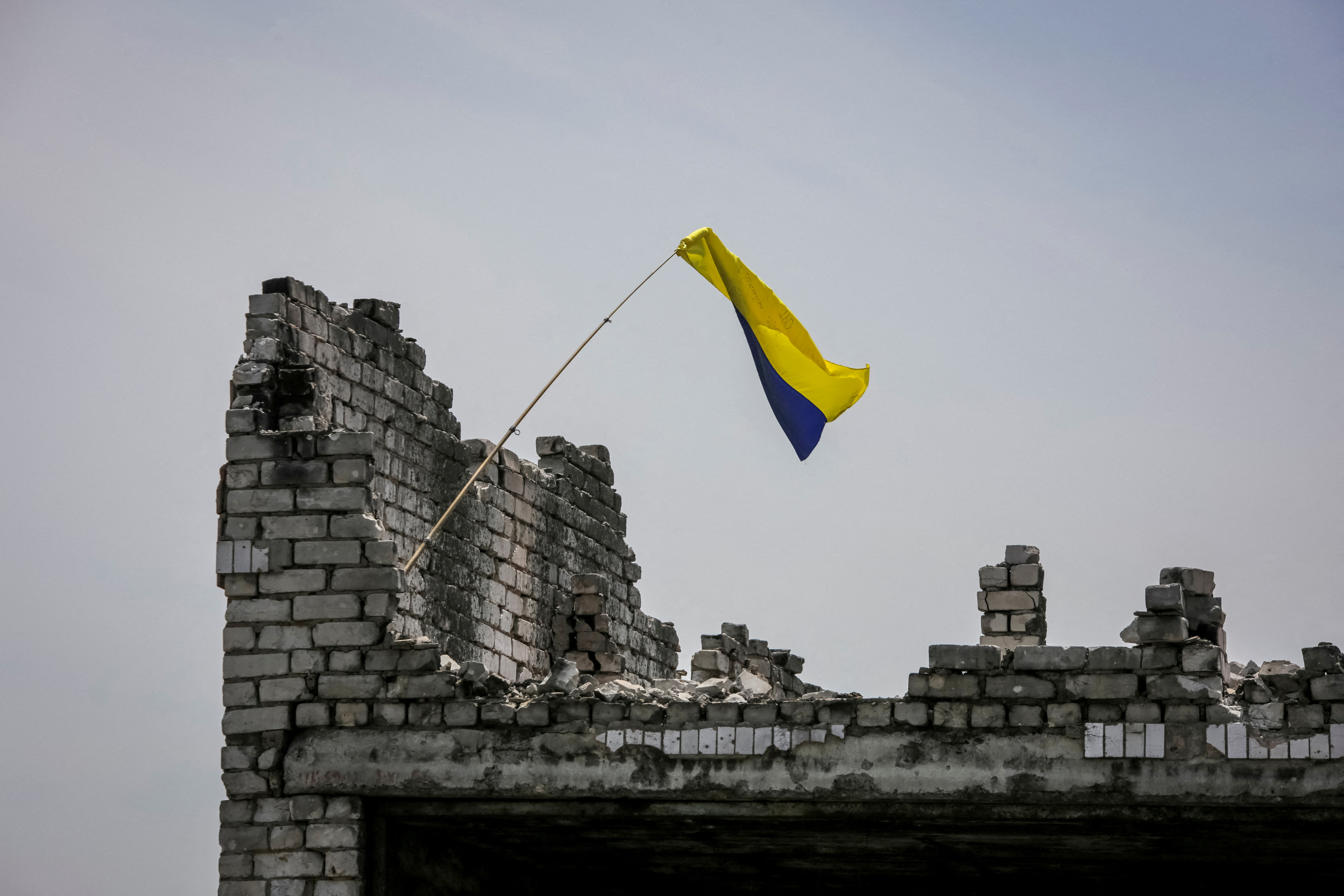 A Ukrainian flag flying from a ruined building near the front line in the village of Neskuchne in Ukraine's Donetsk region
