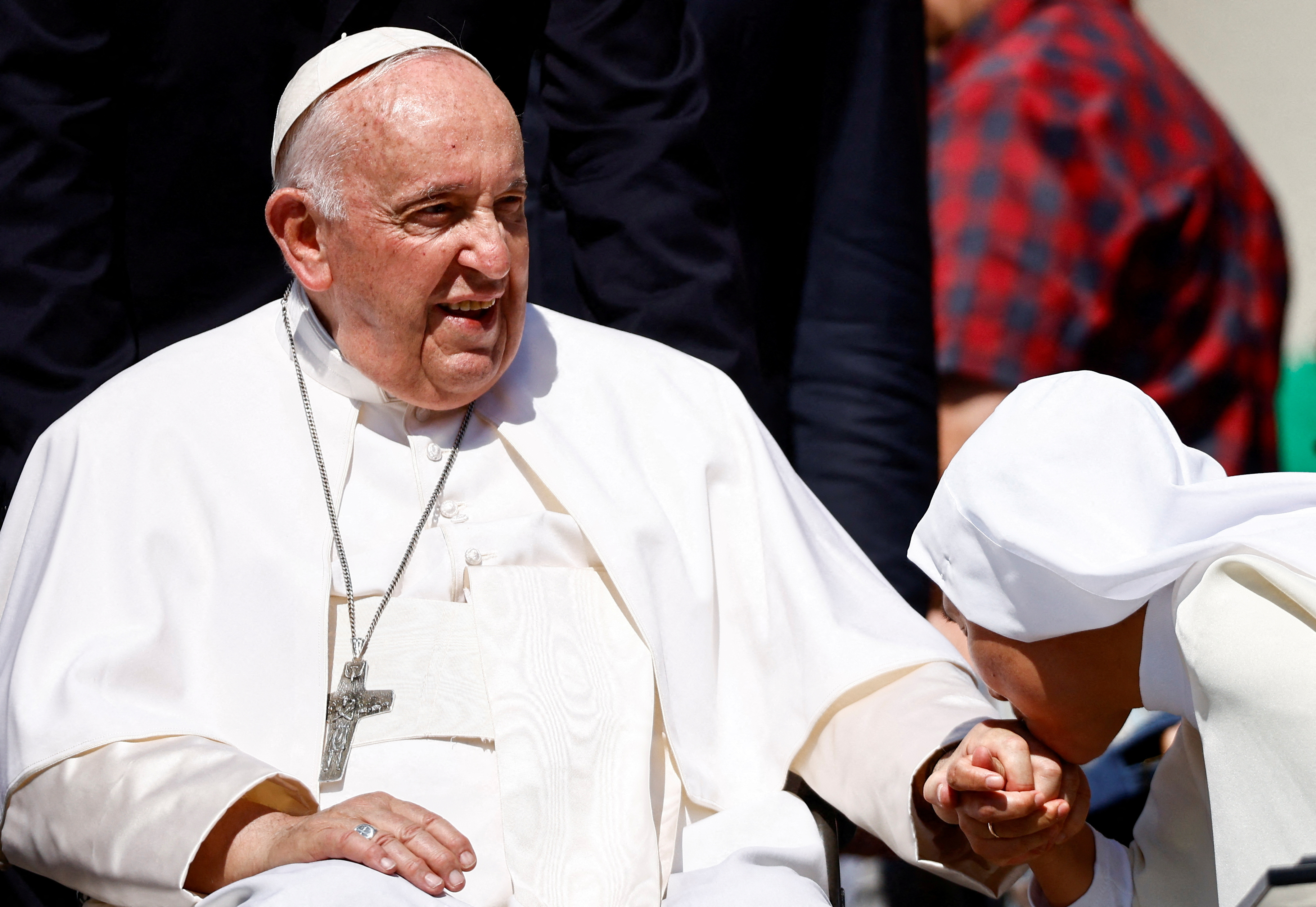 A nun kisses the hand of Pope Francis during the weekly general audience on the day he was due to undergo abdominal surgery in St Peter's Square on June 7, 2023