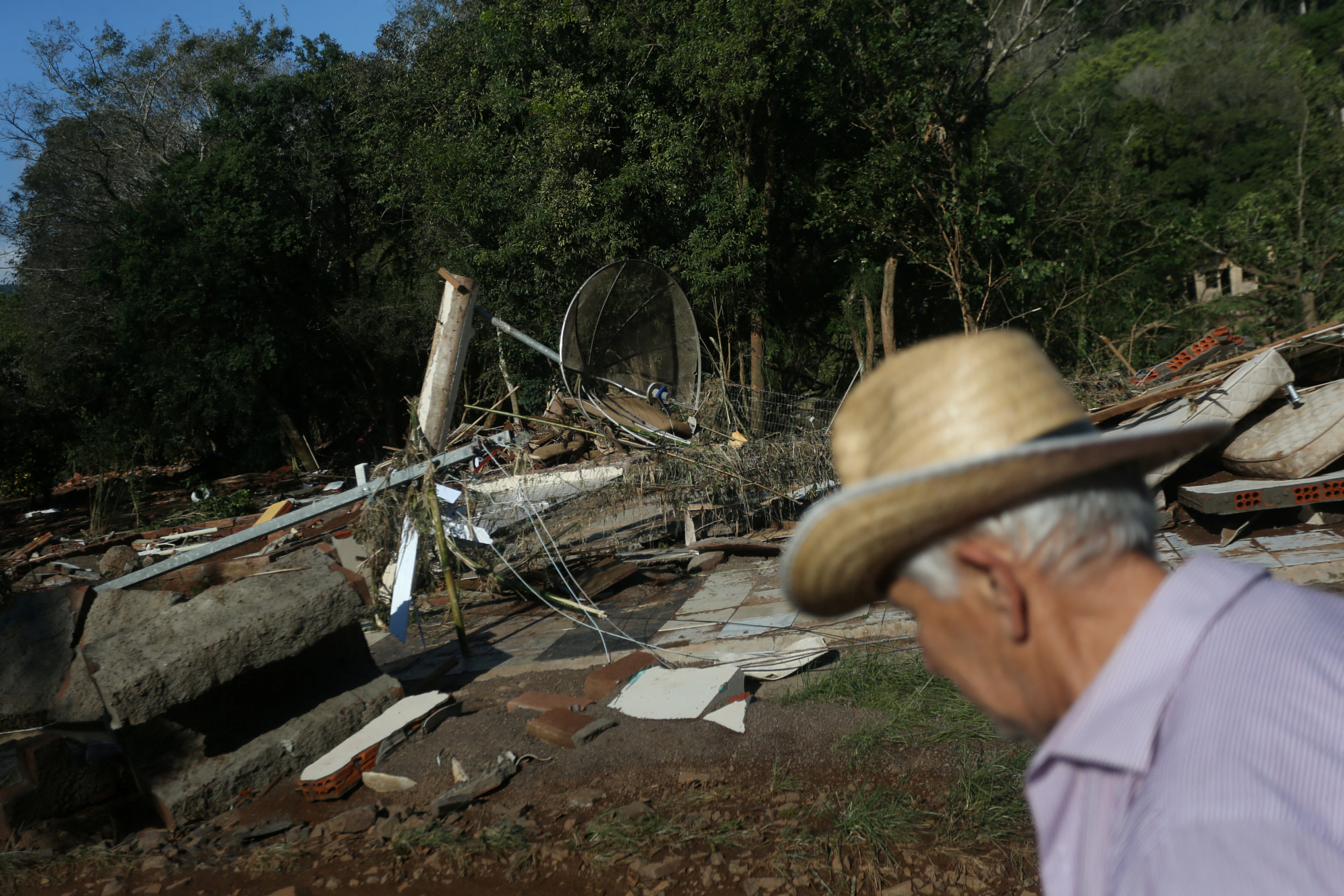 A resident walks near debris after flooding due to heavy rains following an extratropical cyclone, in Caraa