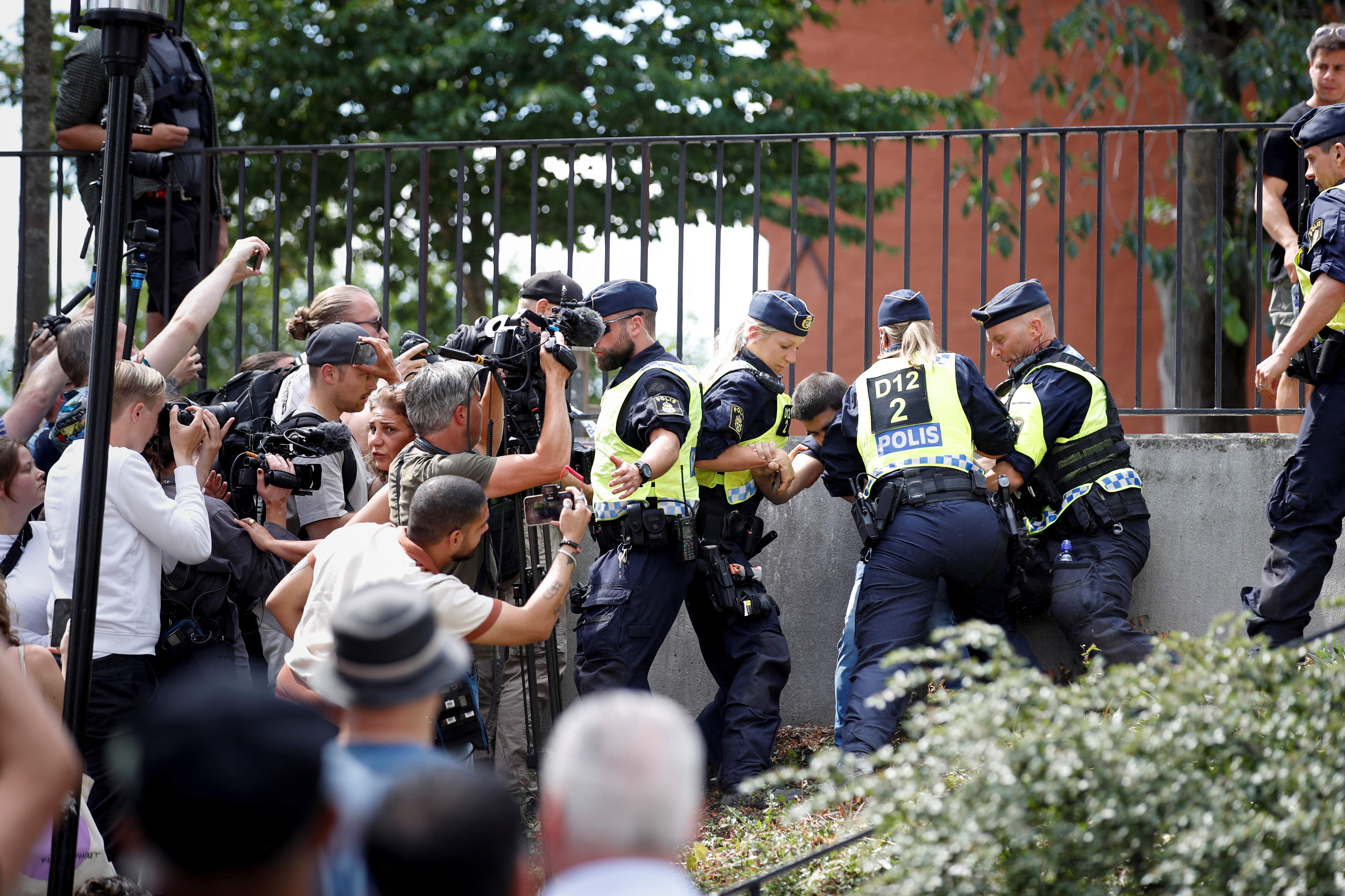 Police officers intervene after people's reaction as demonstrators burn the Koran (not pictured) outside Stockholm's central mosque in Stockholm, Sweden June 28, 2023.