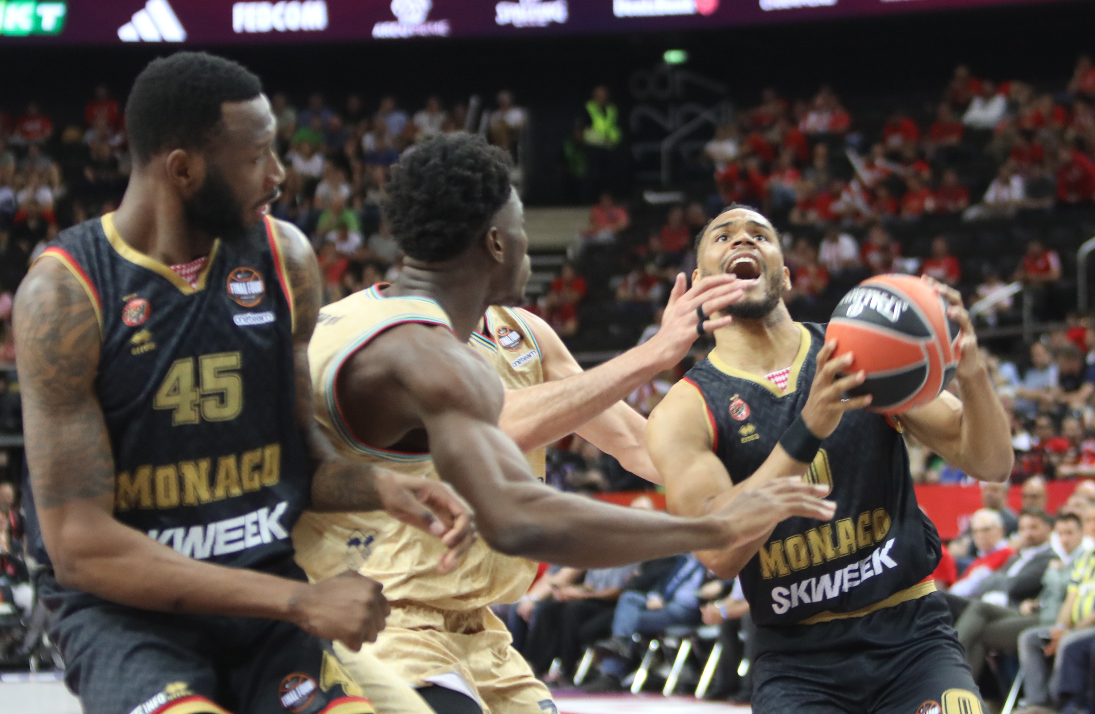 Barcelona's James Nnaji (C) and AS Monaco' Elie Okobo (R) vie for the ball during the Euroleague basketball final four match for third place between Monaco and Barcelona in Kaunas, on May 21, 2023. (Photo by PETRAS MALUKAS / AFP)