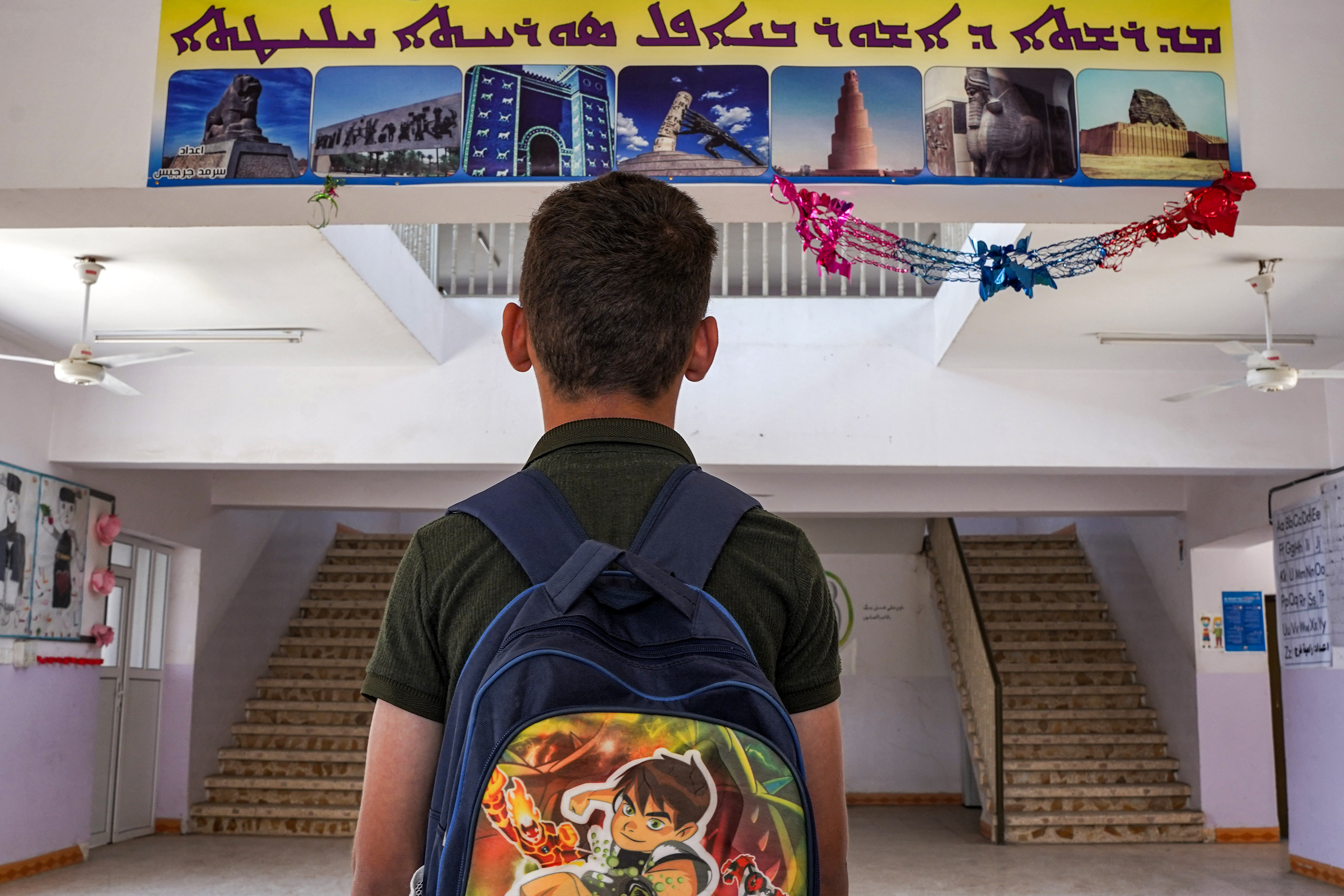 a boy views a sign written in Syriac at the Ashurbanipal Syriac School in Iraq's predominantly Christian town of Qaraqosh (Baghdeda), in Nineveh province.