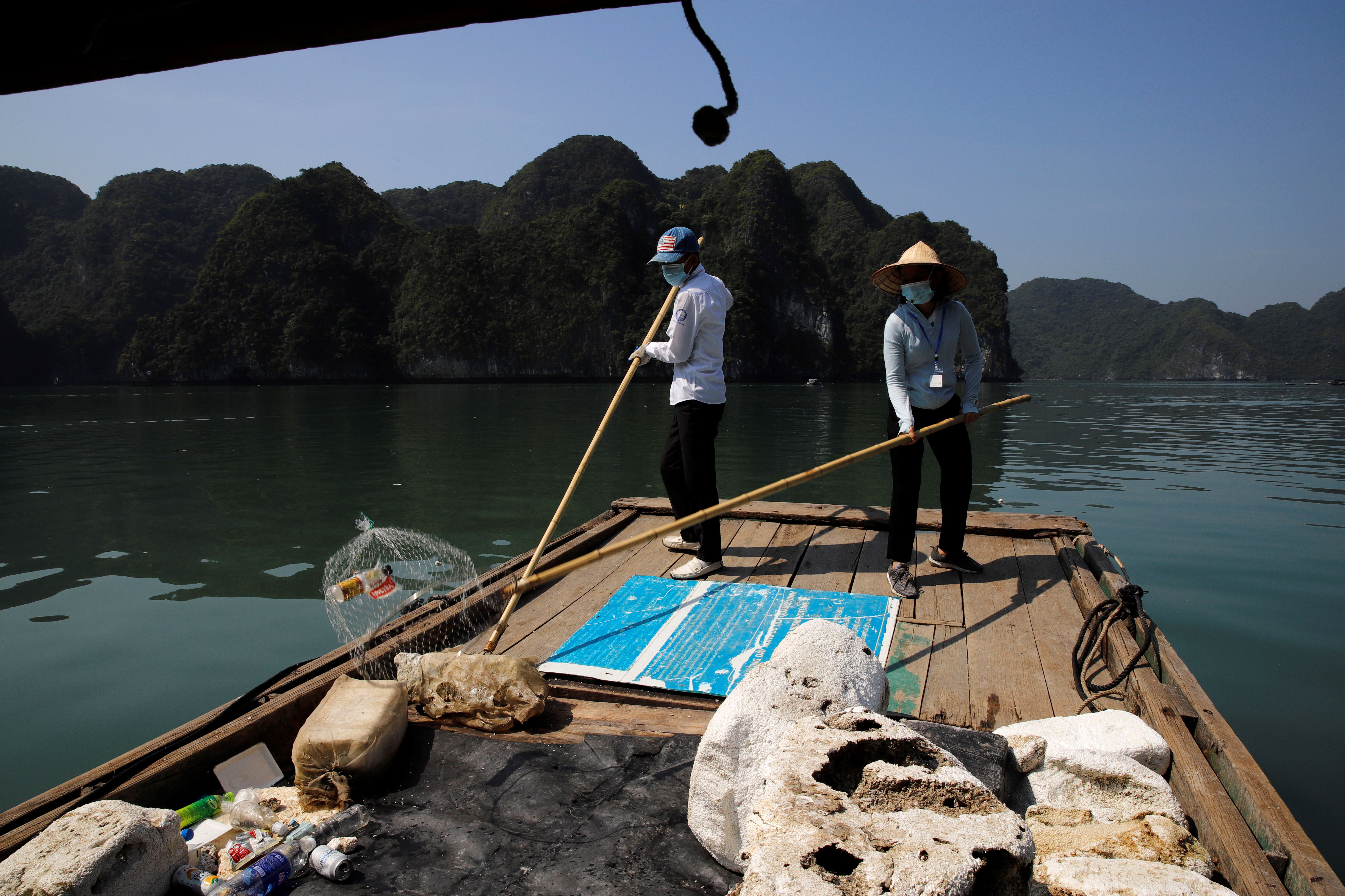 a worker picks up trash from Ha Long Bay in northeast Vietnam.