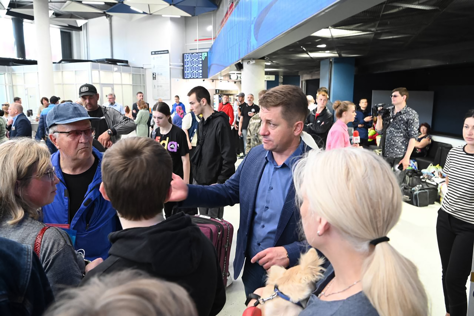 Belgorod mayor Valentin Demidov visiting a temporary shelter for residents. He is surrounded by men and women.