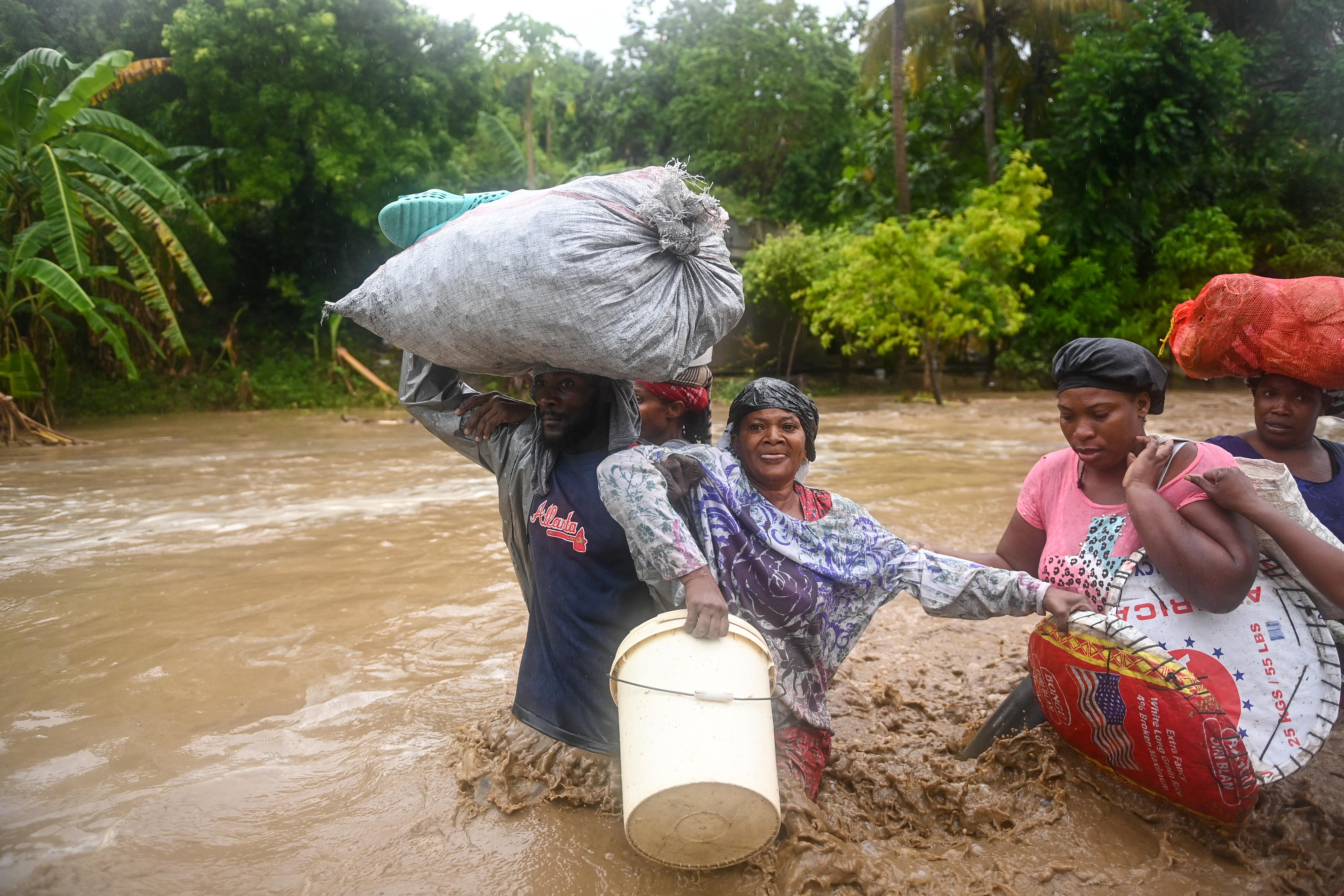 Residents cross the submerged Route Nationale