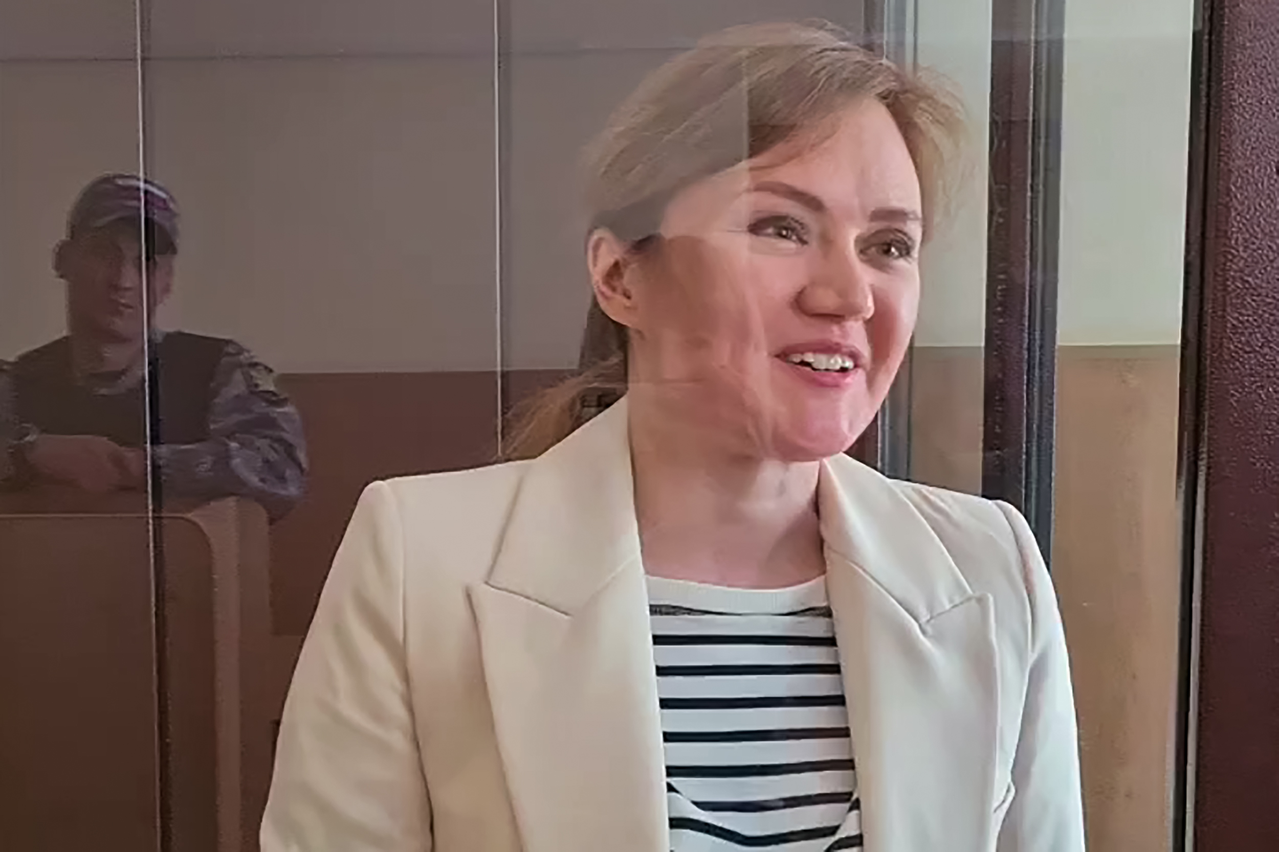 Lilia Chanysheva, ally of Russian opposition figure Alexei Navalny and a former regional coordinator of Navalny's political group in the city of Ufa in the southern Urals, charged with creating an extremist organisation, looks out from inside a defendants' cage during her verdict hearing at the Kirovsky district court of Ufa