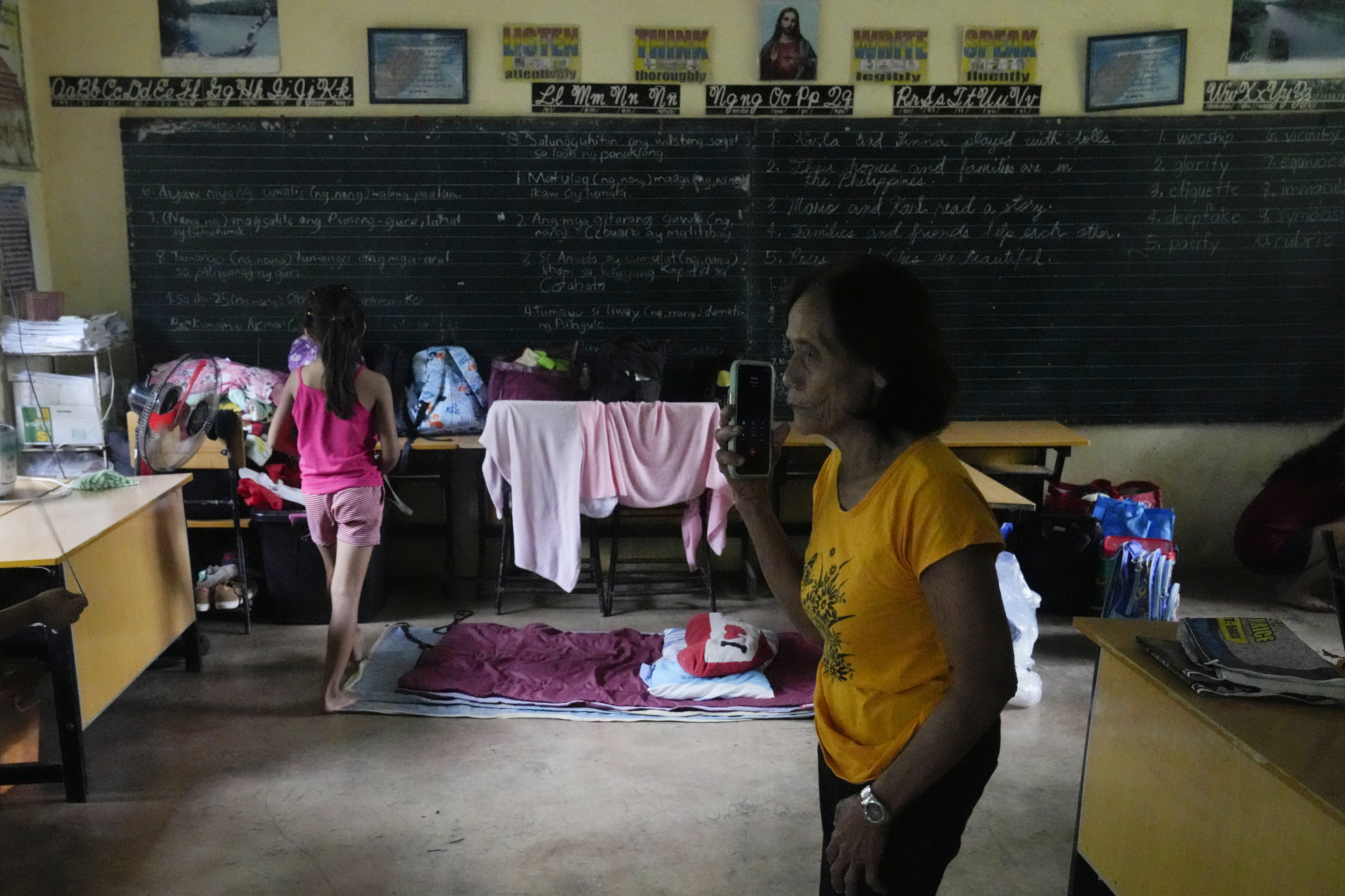 Evacuees wait at a temporary relocation site at a school in Daraga town