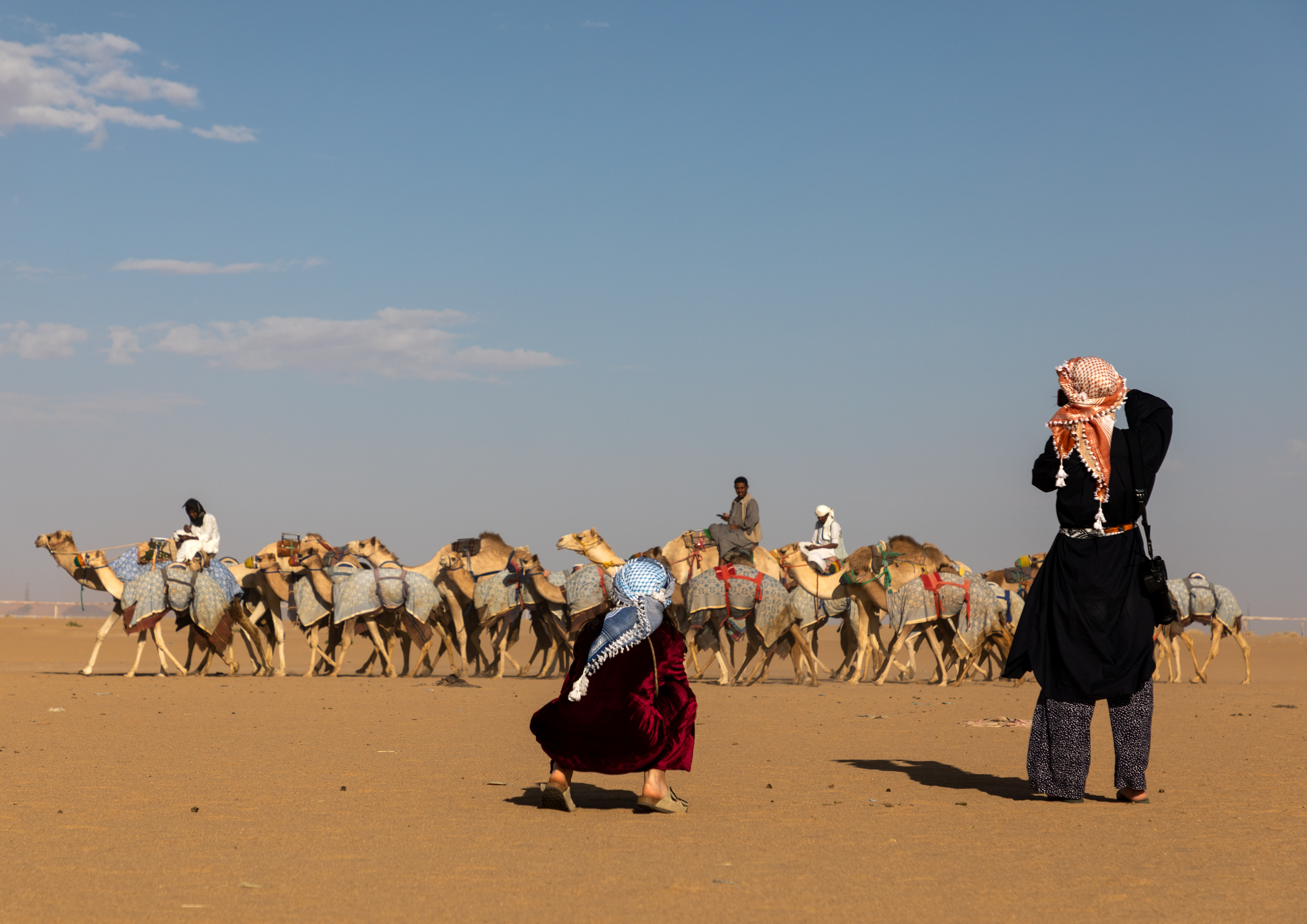 Tourists taking pictures during the training for camel racing