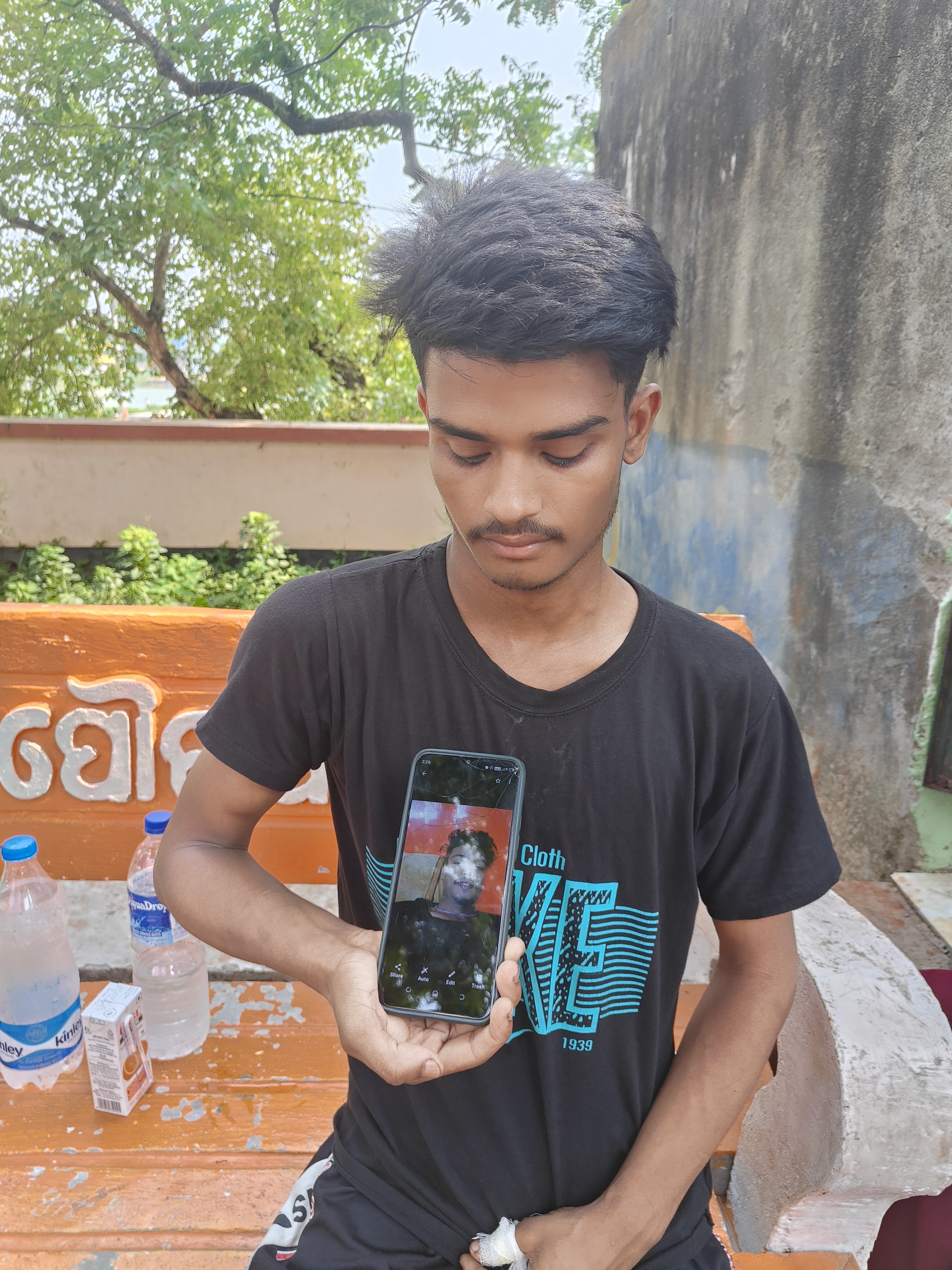 Survivor Afzal with a photo of his friend Mazhar