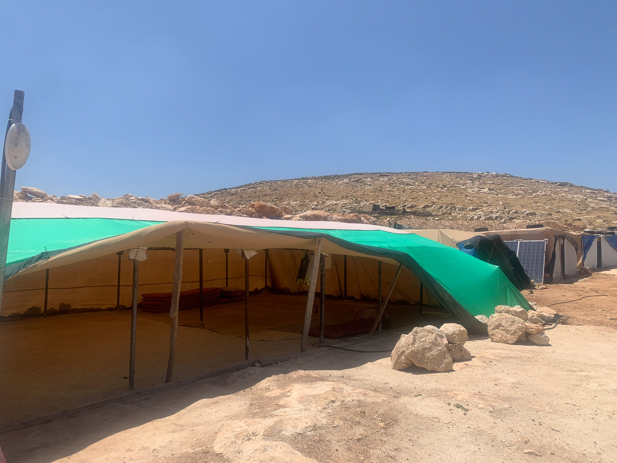 A look inside a temporary tent where four to five families sleep, open to the elements on one side