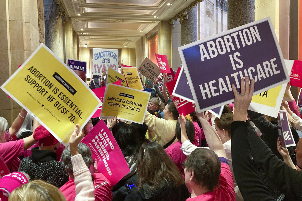 Protestors hold signs in the state capital
