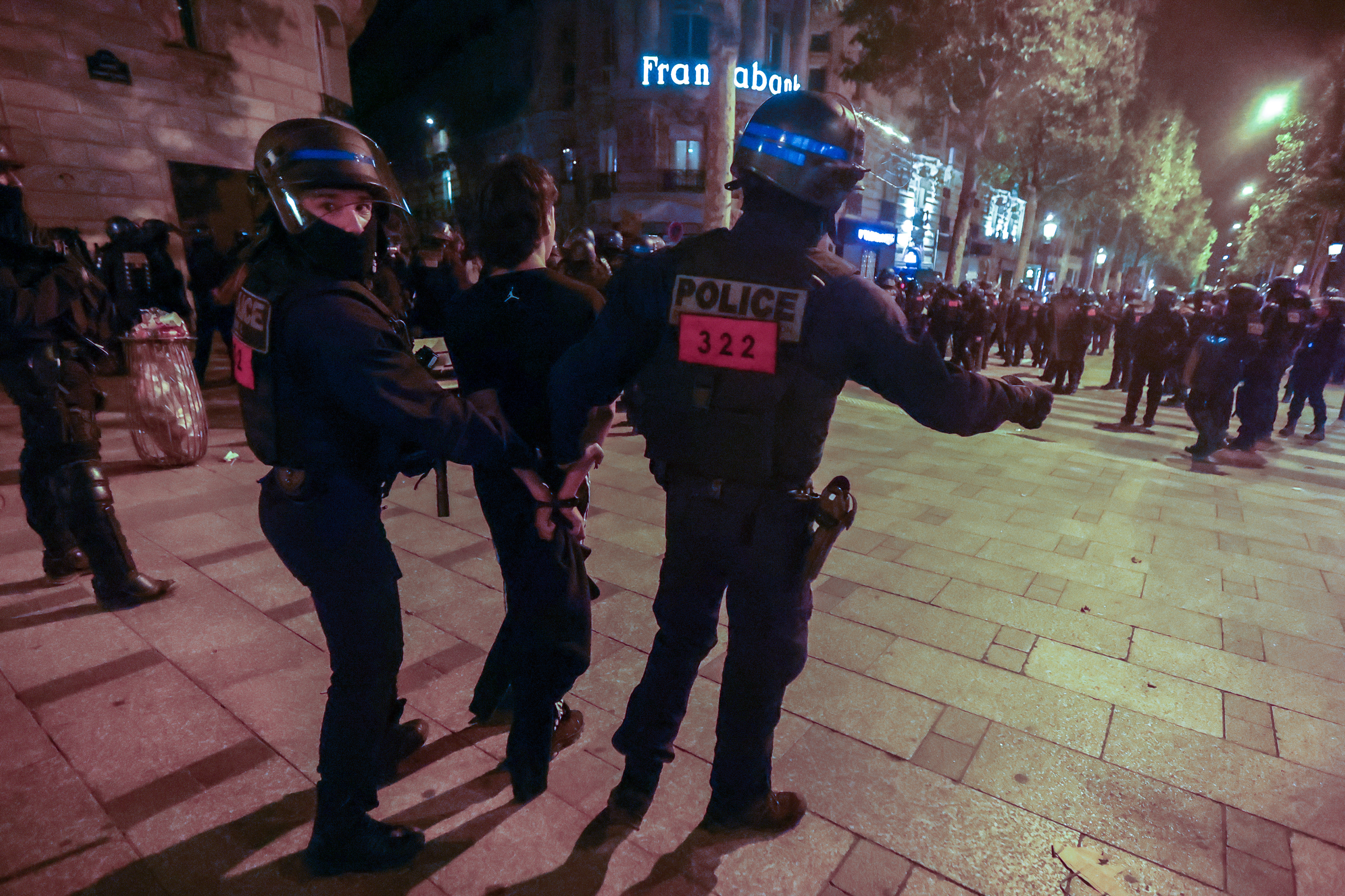Riot police forces clash with demonstrators near the Arc de triomphe during another night of clashes with protestors in Paris