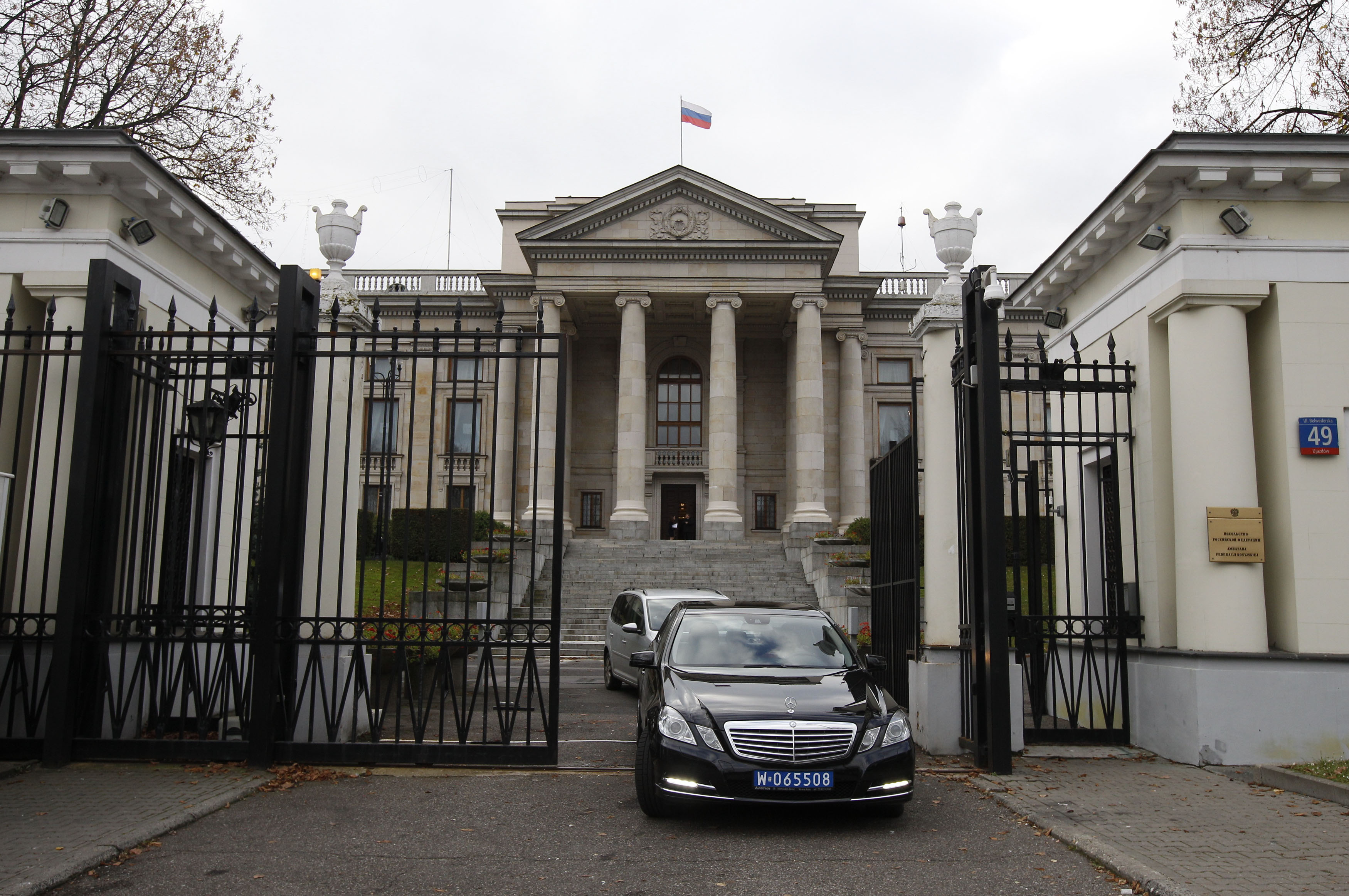 Vehicles drive out of the main entrance of the Russian embassy compound in Warsaw