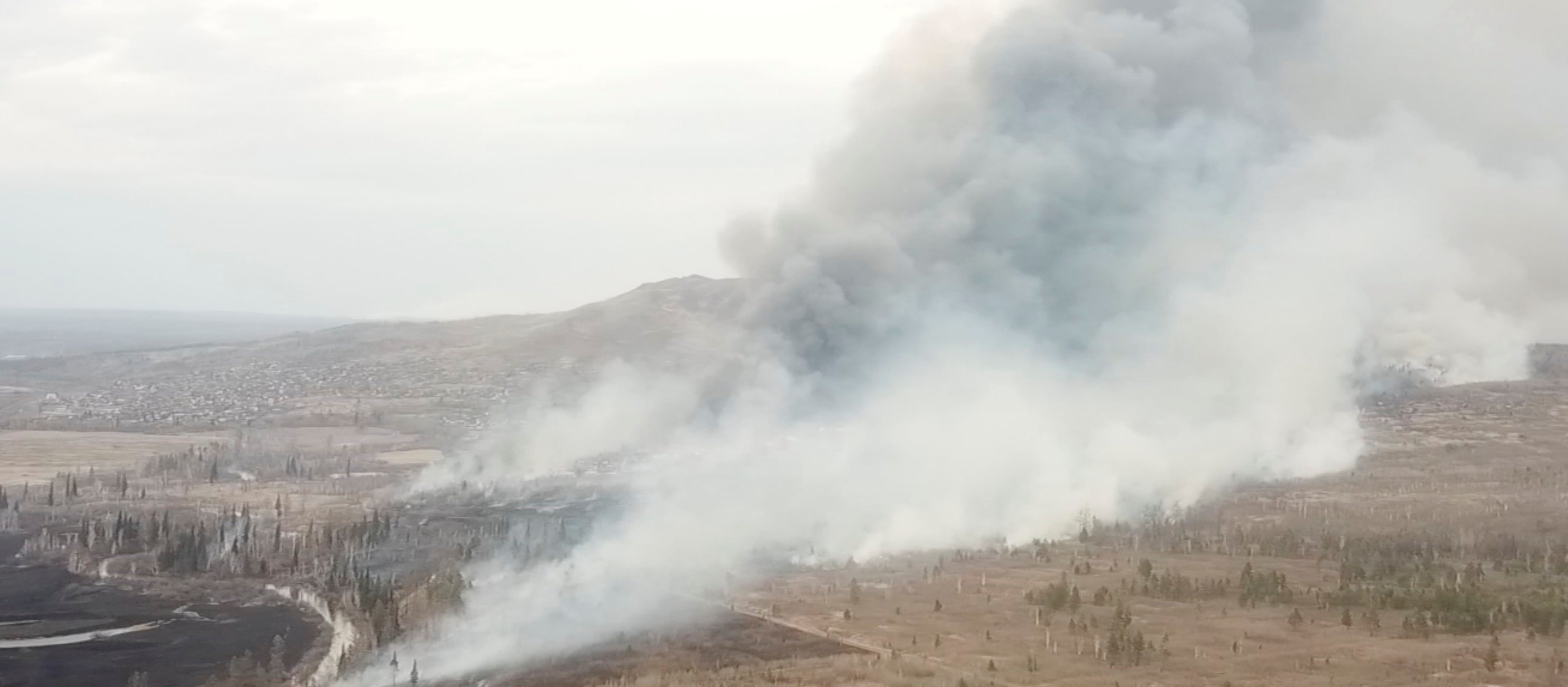 Smoke from a wildfire rises above the village of Morgudon in the Irkutsk Region, Russia, in this still image taken from a video. Video taken May 7, 2022. REUTERS TV via REUTERS