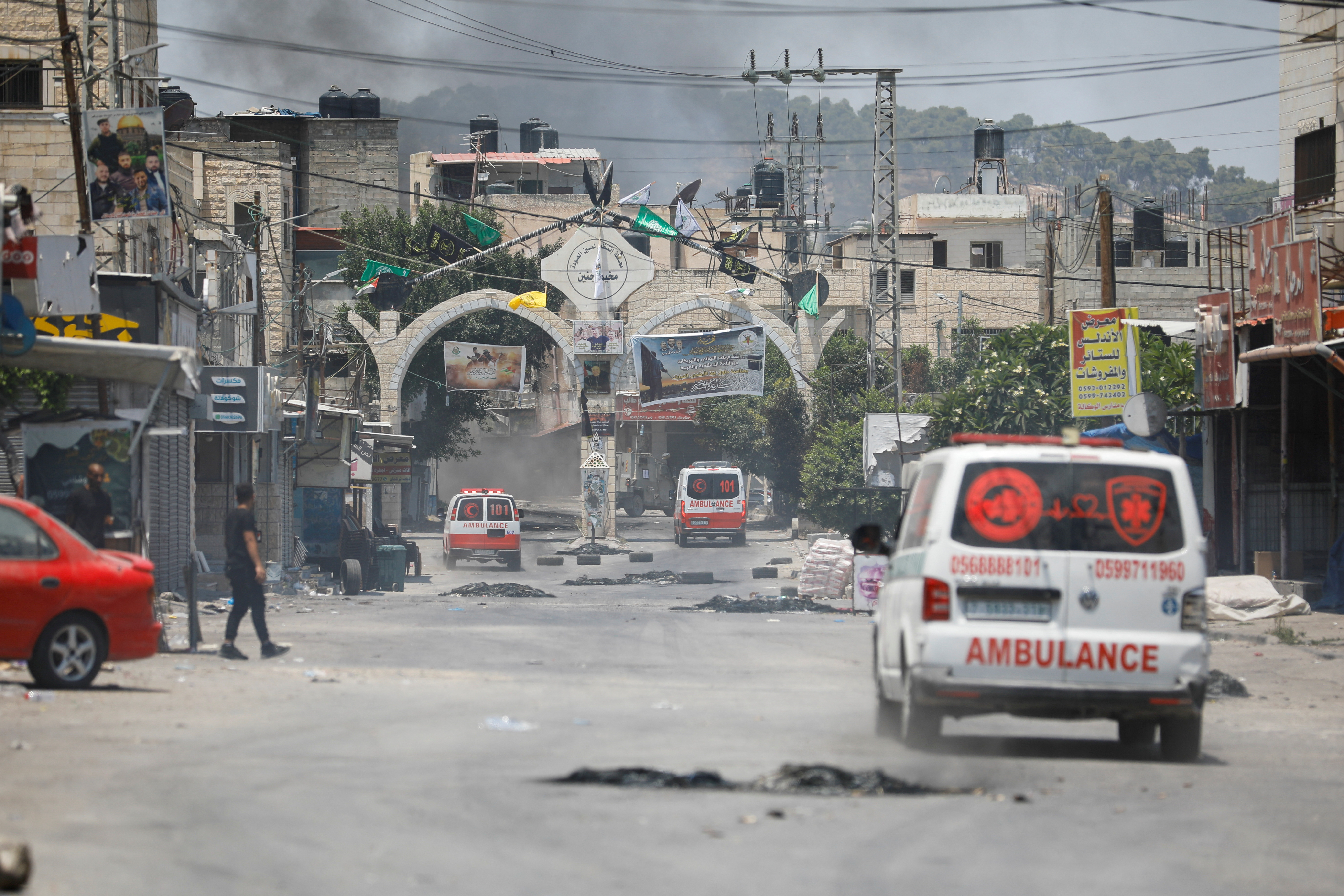Smoke rises as ambulances drive during an Israeli military operation in Jenin