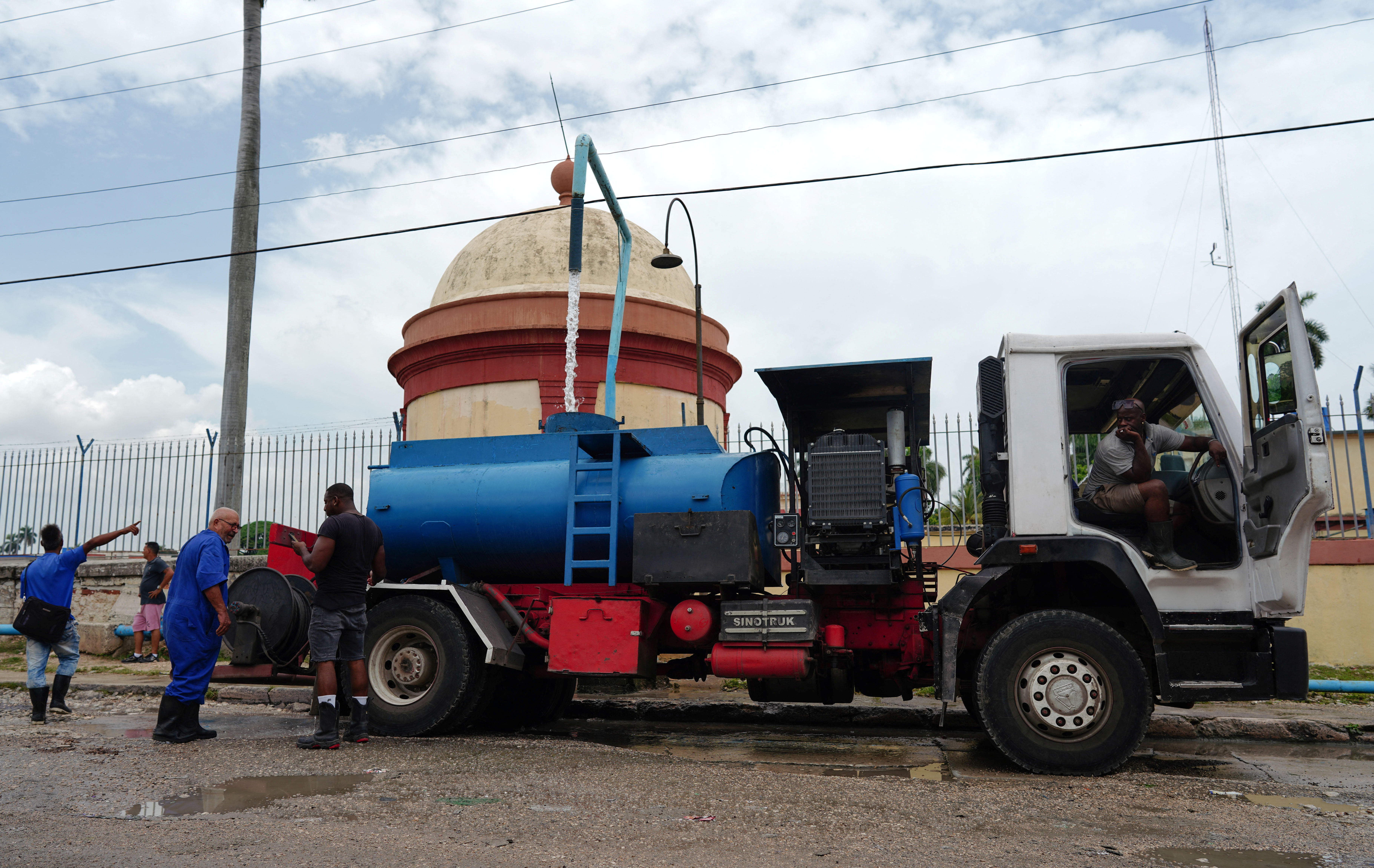 A driver fills up the tank of a water truck in Havana, Cuba,