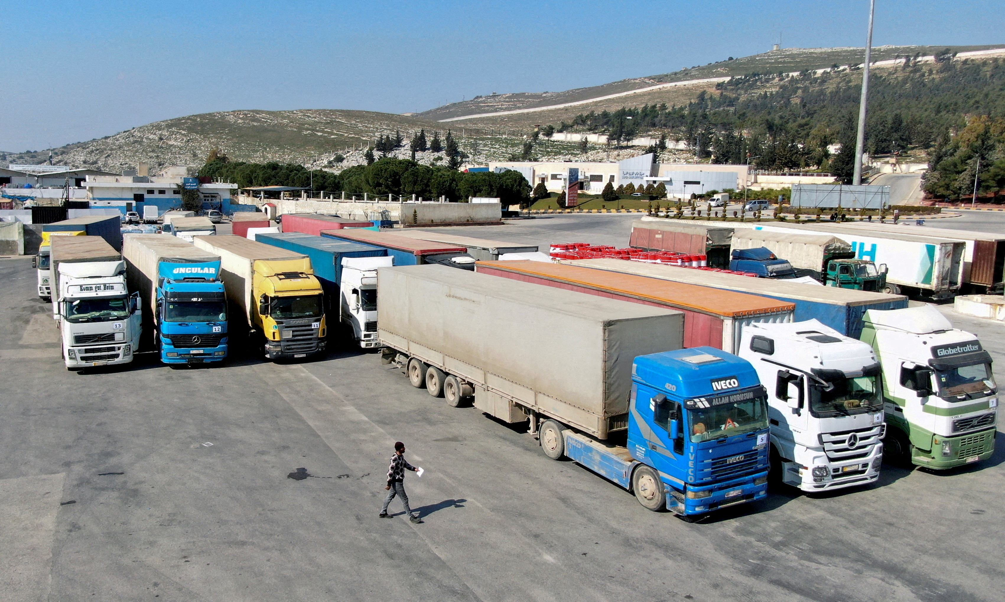 Trucks carrying aid from the UN World Food Programme (WFP), following a deadly earthquake, are parked at Bab al-Hawa crossing, Syria, February 20, 2023.