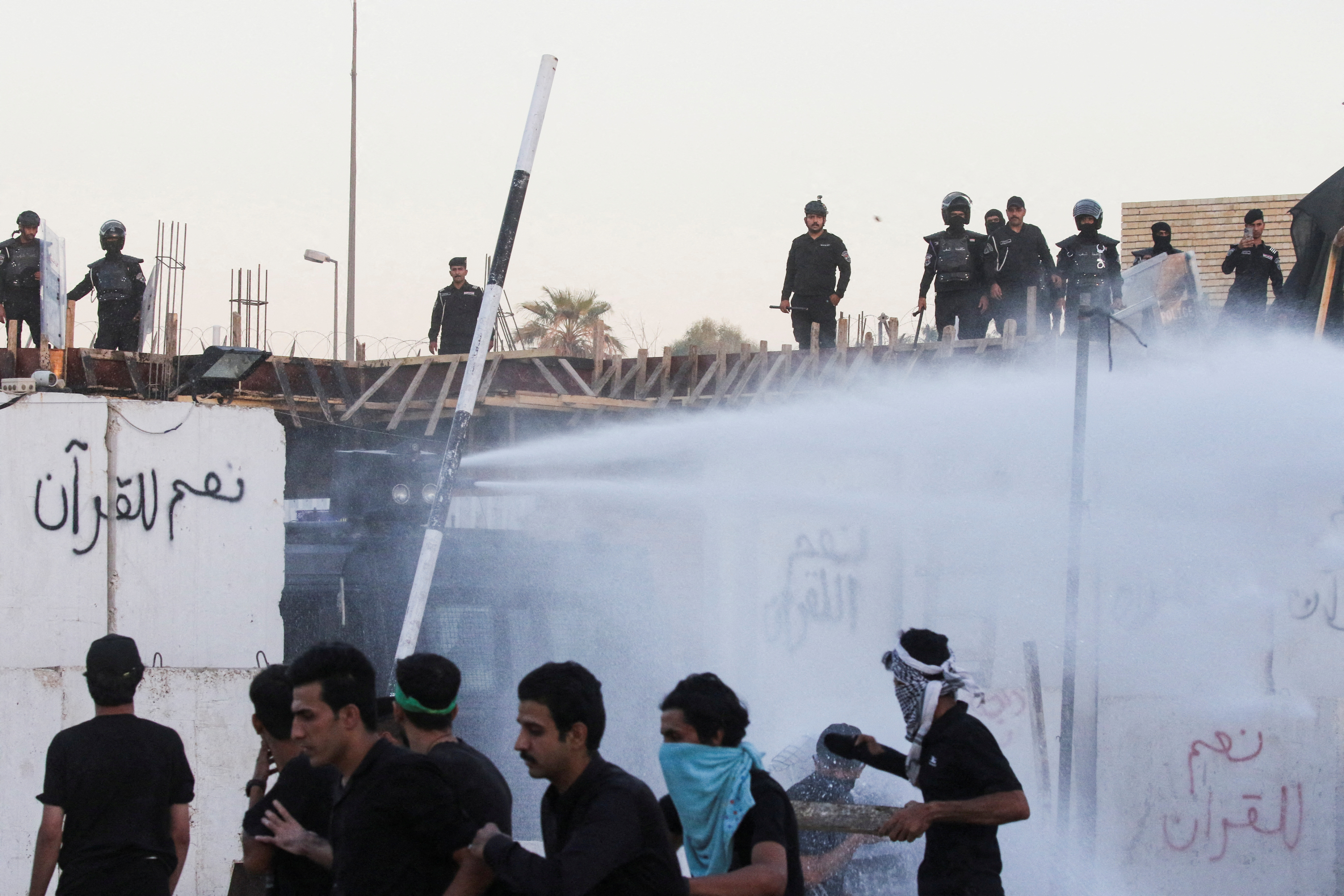 Security forces deploy a water cannon as protesters gather near the Swedish embassy in Baghdad hours after the embassy was stormed and set on fire ahead of an expected Koran burning in Stockholm, in Baghdad, Iraq, July 20, 2023. REUTERS/Ahmed Saad REFILE - CORRECTING "FIREFIGHTERS SPRAY WATER" TO "SECURITY FORCES DEPLOY A WATER CANNON