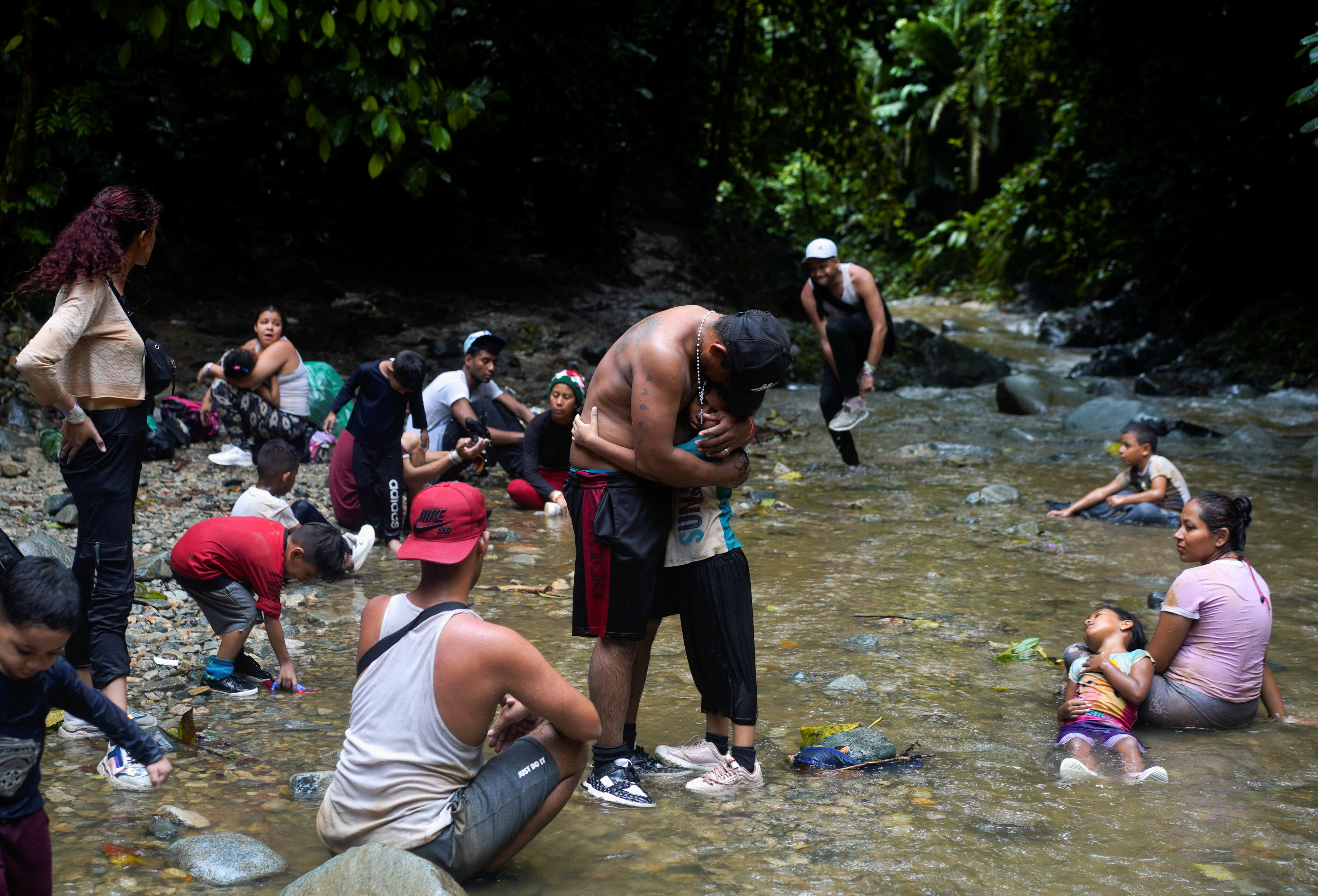A migrant from Ecuador hugs his exhausted daughter,