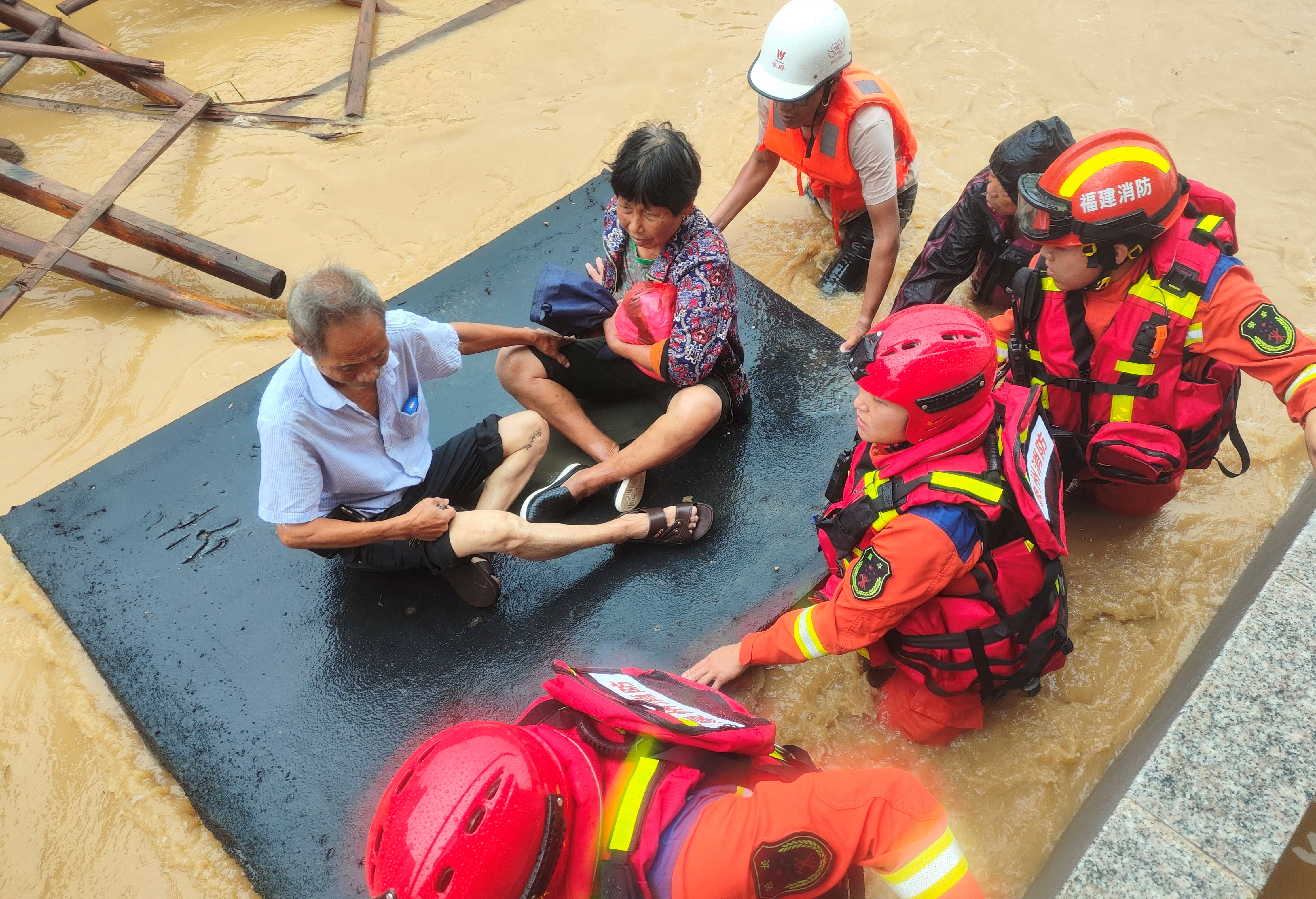 Firefighters evacuate residents stranded by floodwaters after Typhoon Doksuri made landfall in Quanzhou, Fujian province, China