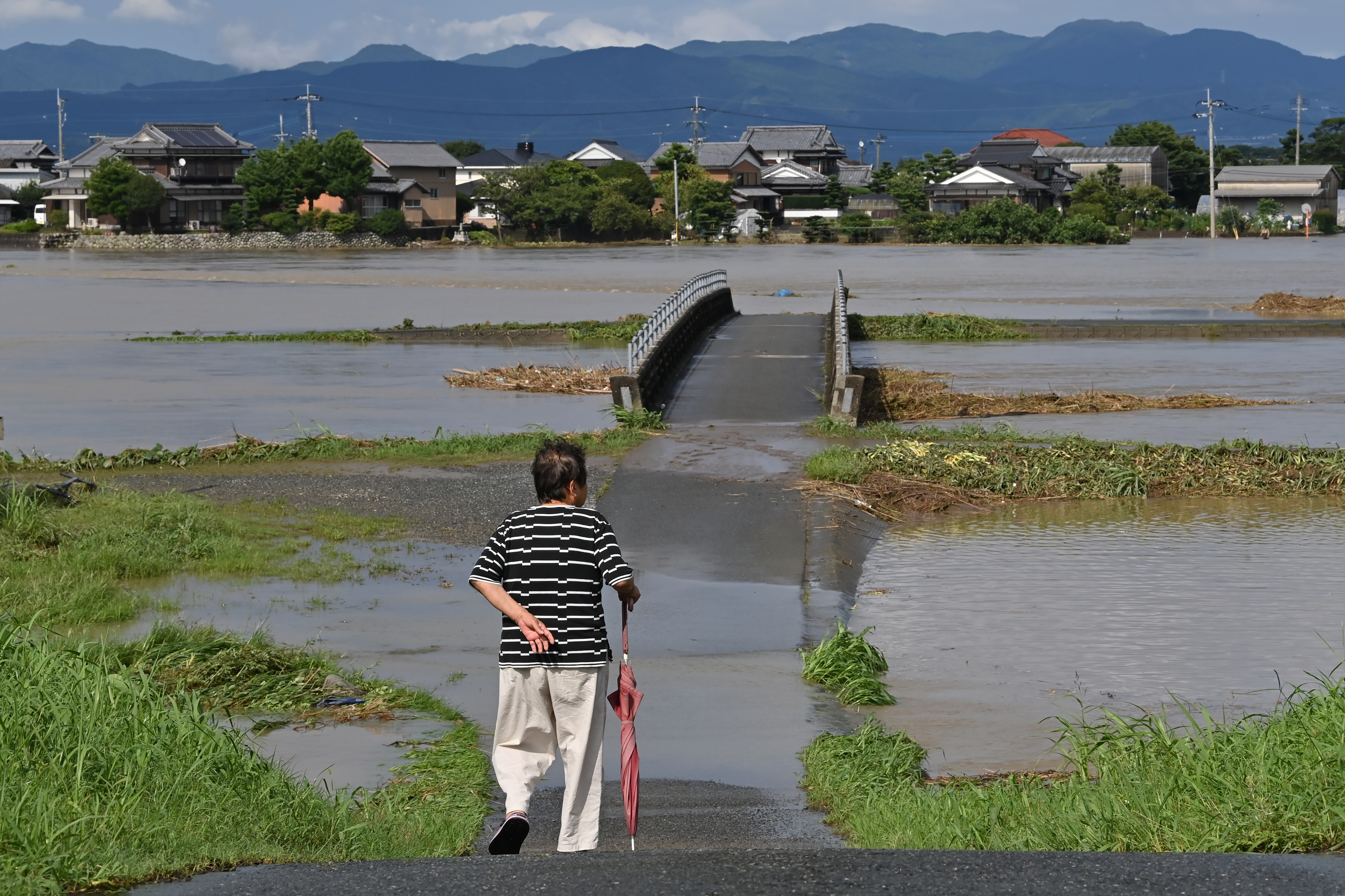 A woman looks out over an area covered in water