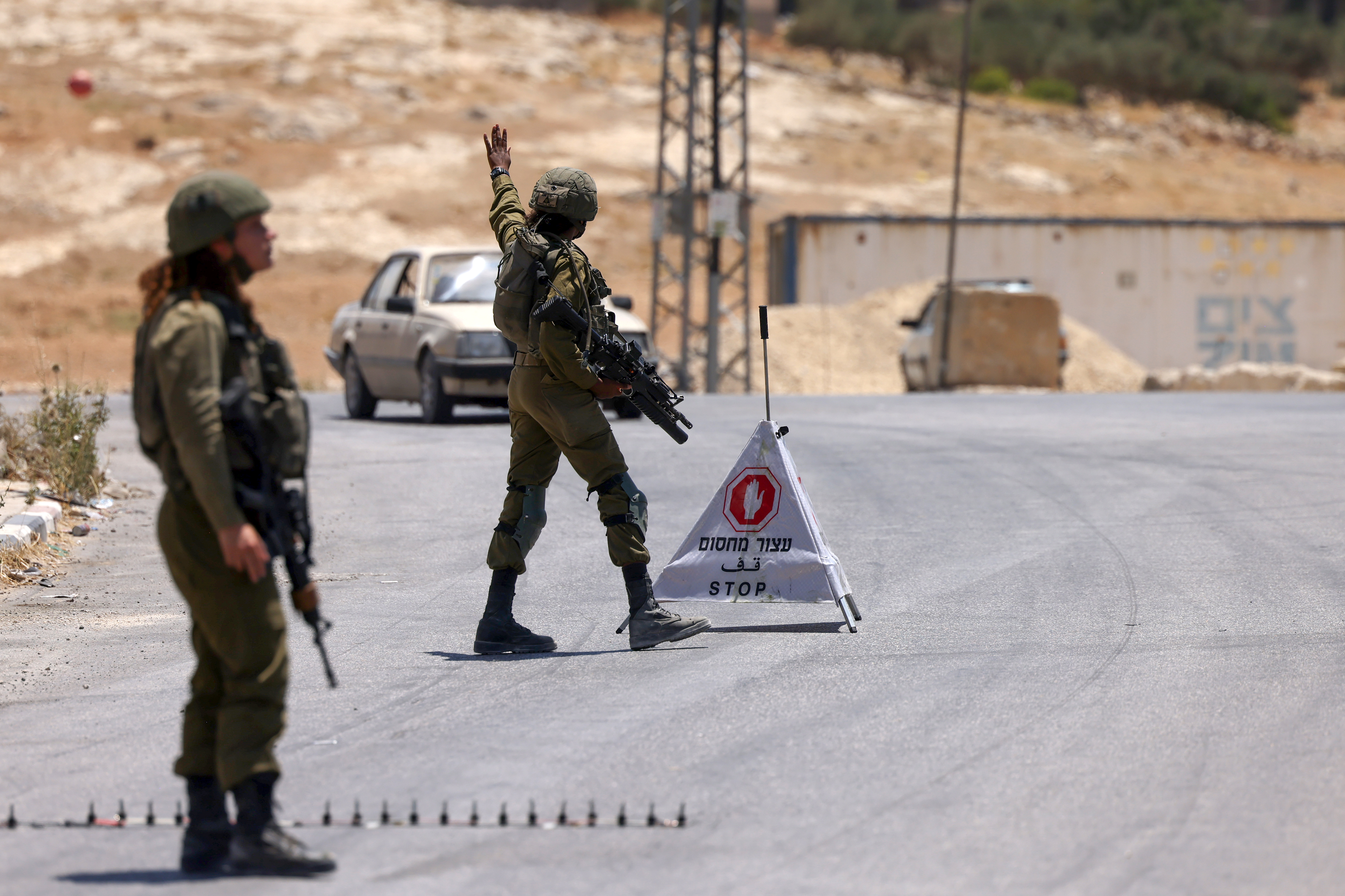 Israeli soldiers block the road leading to the occupied West Bank town of Janatah south of Bethlehem