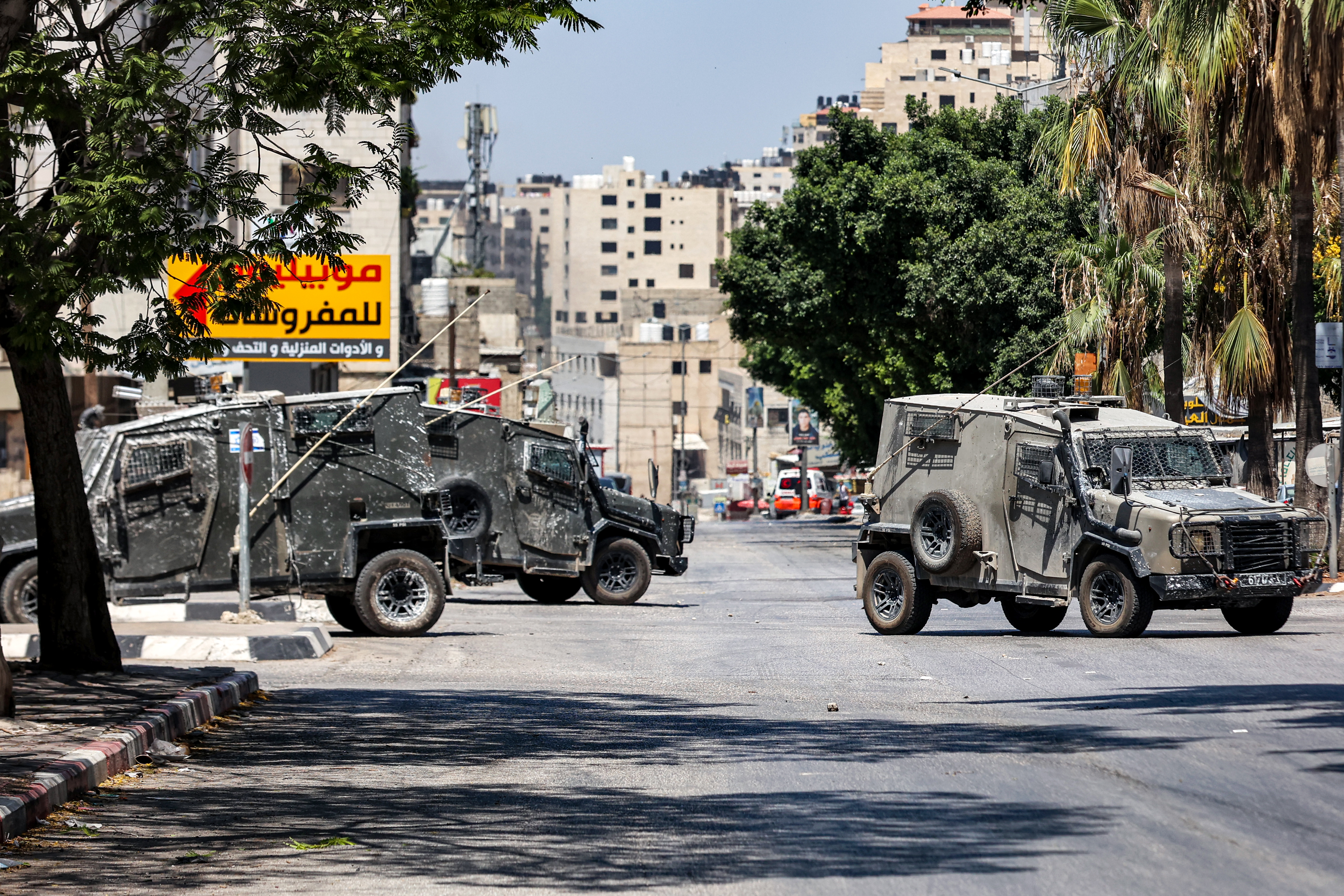 Israeli army vehicles are pictured along a road during an army raid in al-Ain camp for Palestinian refugees, west of Nablus in the occupied West Bank, on July 26, 2023. (Photo by Zain JAAFAR / AFP)