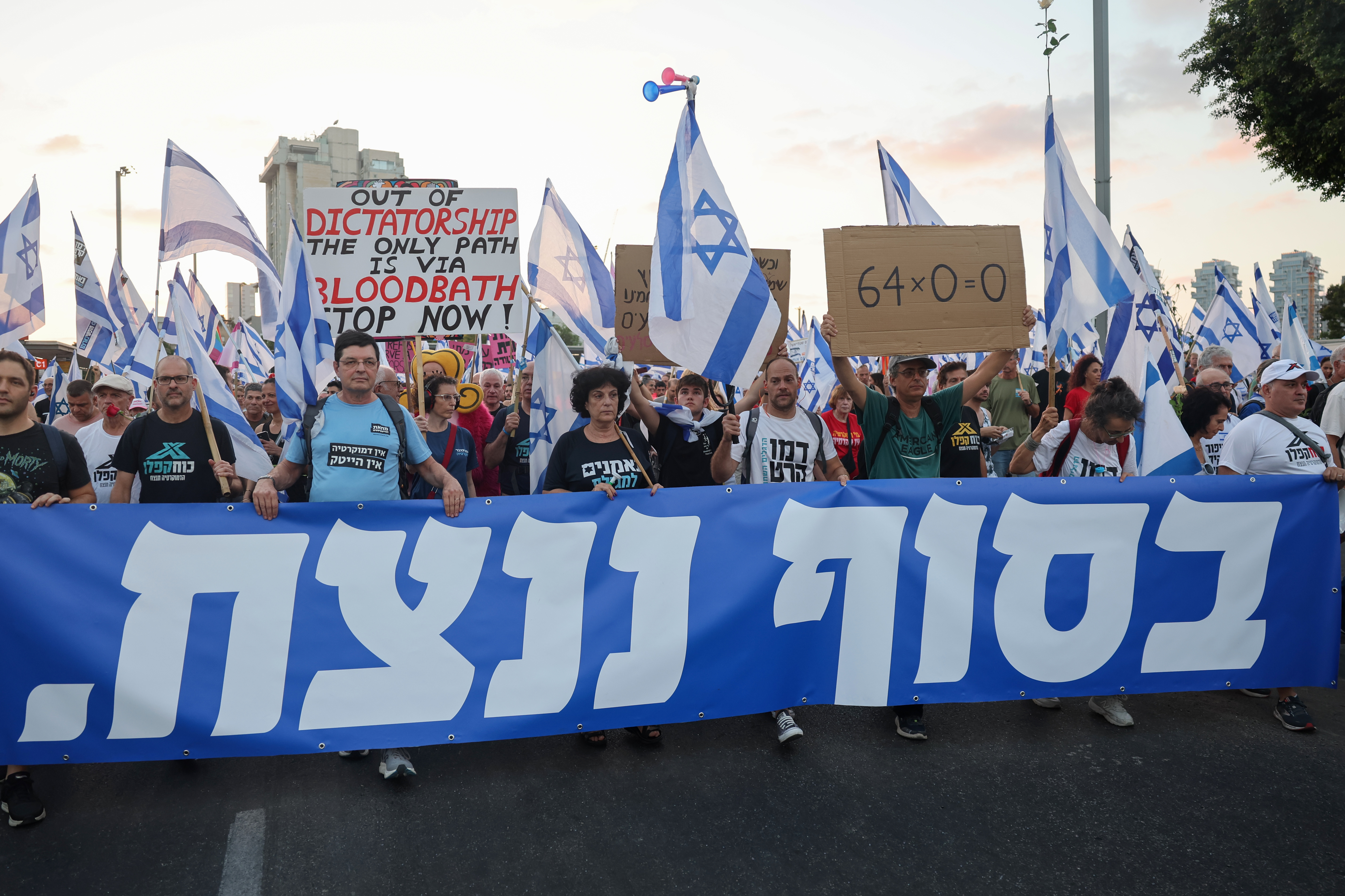 Protestors lift a banner as they march against the Israeli government's judicial overhaul plan