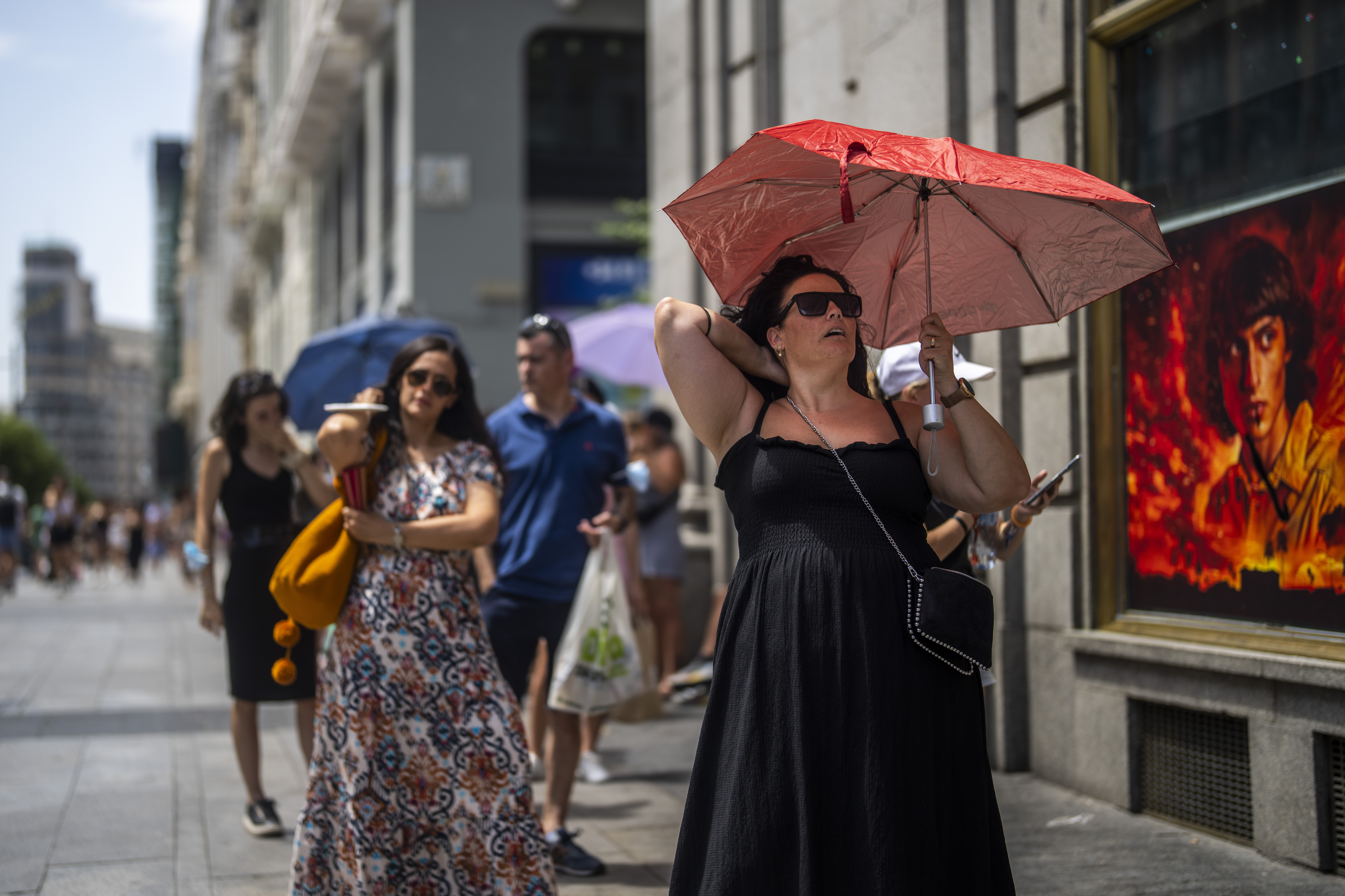 A woman holds an umbrella to shelter from the sun
