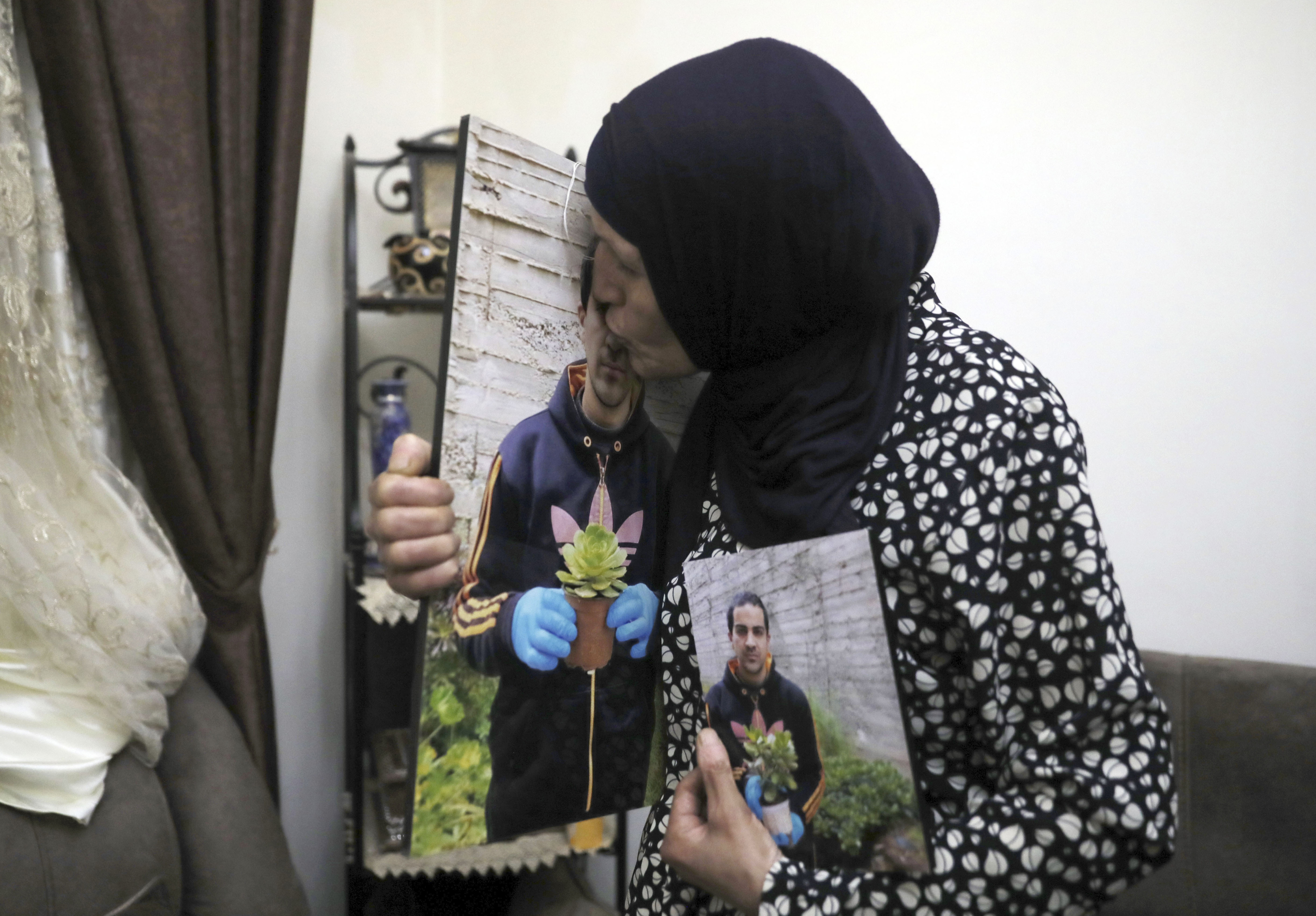 Rana kisses a photo of her son, Eyad Hallaq
