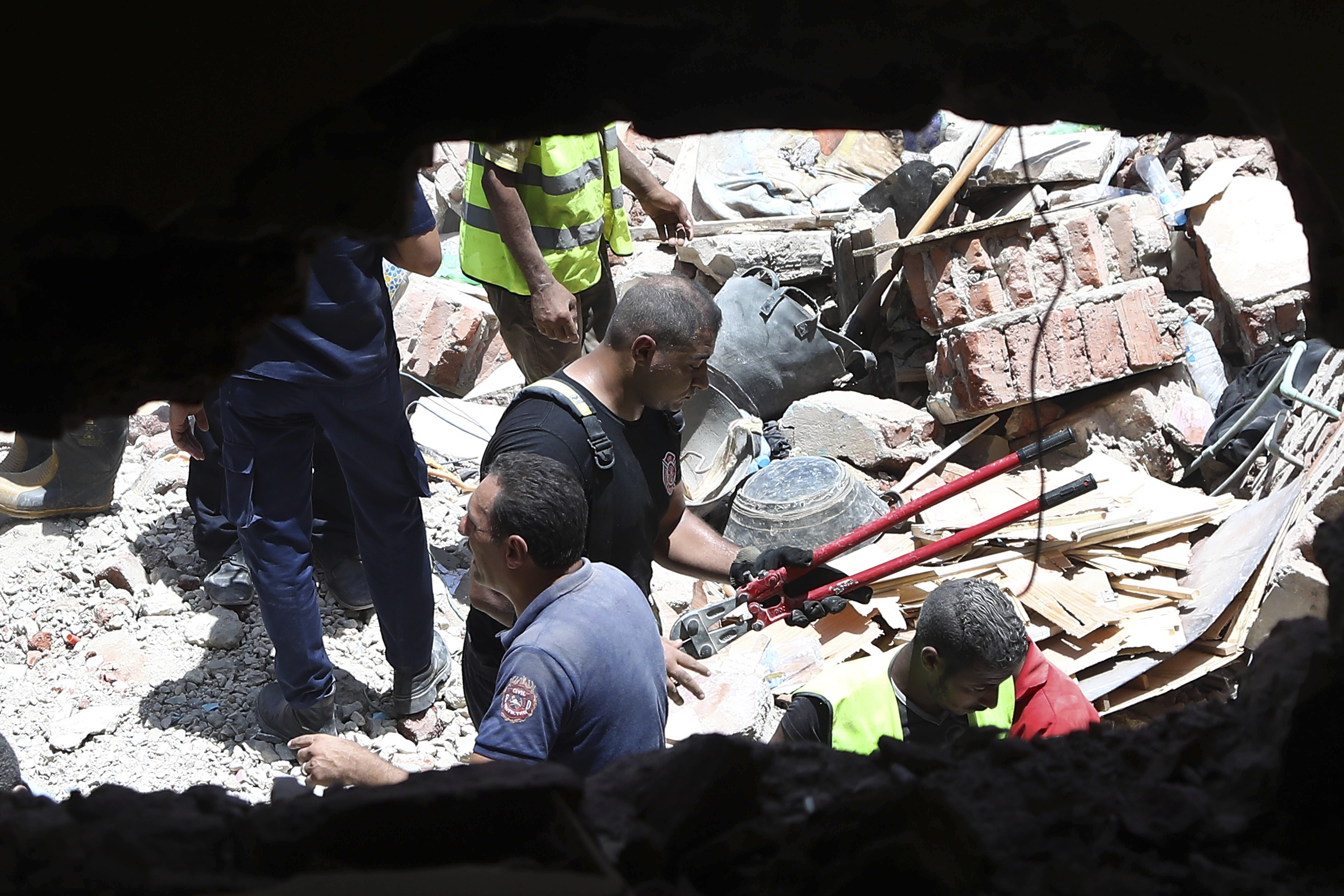 Rescuers search through the rubble of a collapsed five-story apartment building in Cairo, Egypt