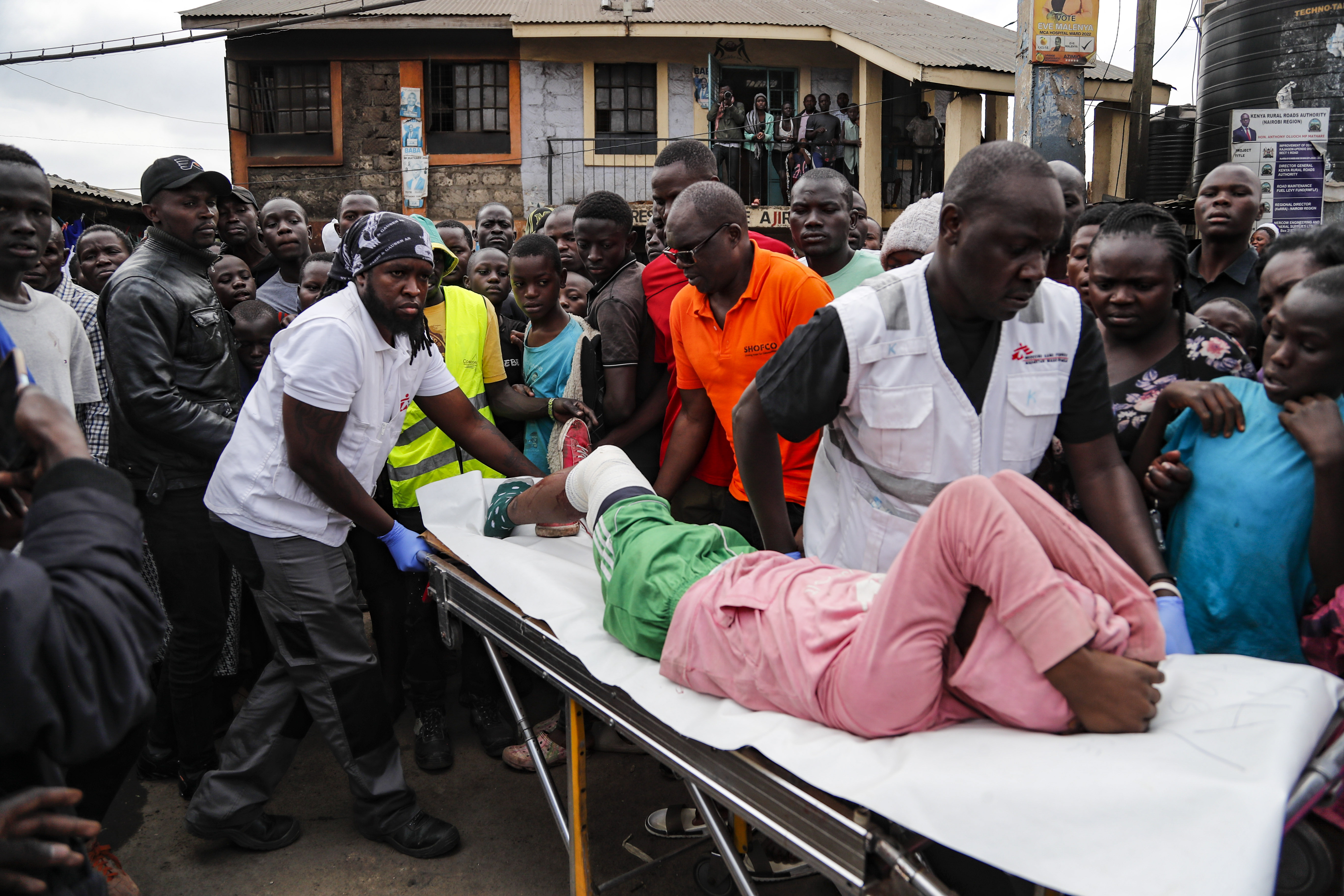 Medecins Sans Frontieres (MSF) responders carry a young boy to an ambulance, as residents said he was wounded in the leg by a stray bullet while standing outside his home in Mathare area of Nairobi,