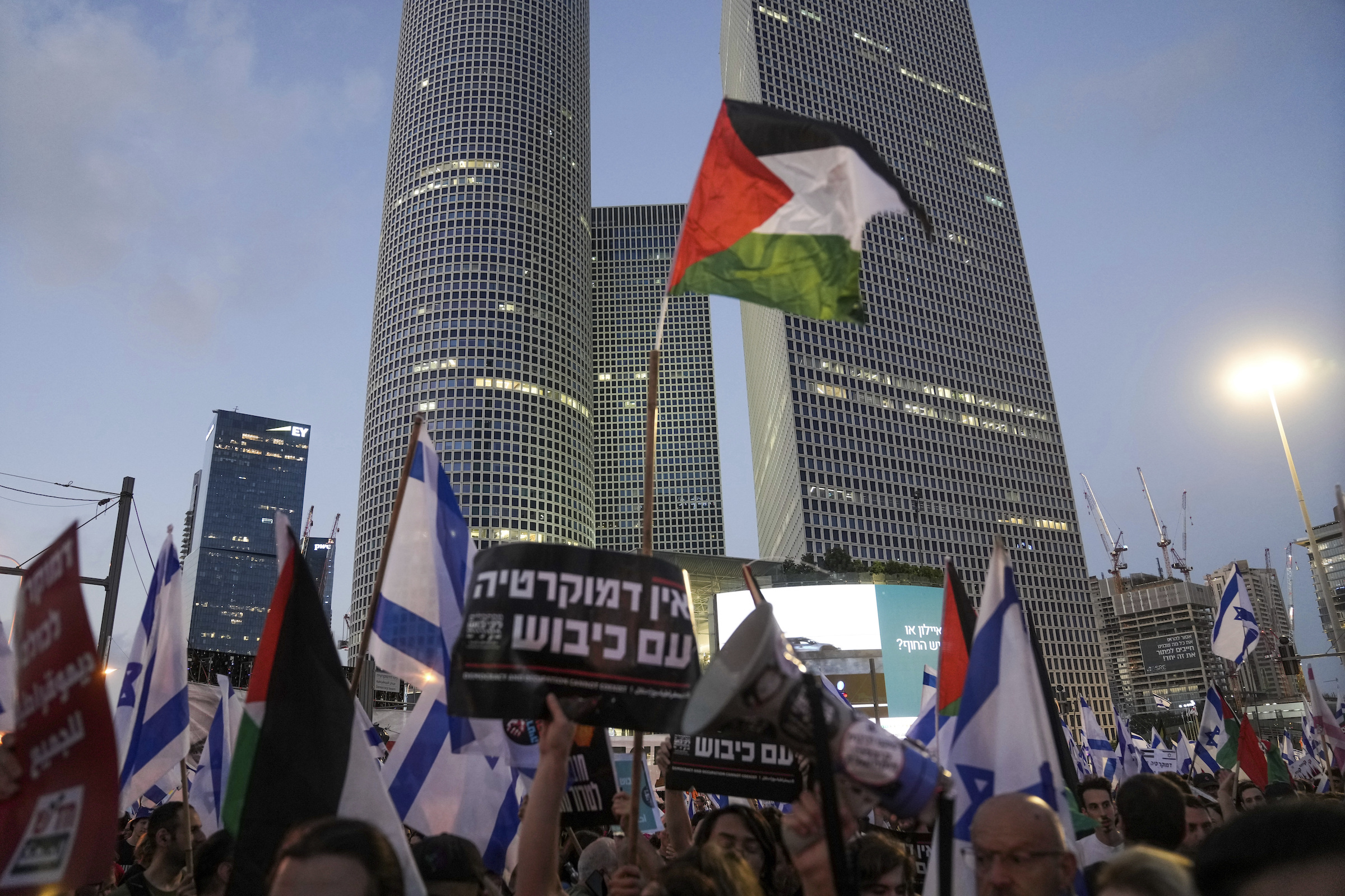 Demonstrators wave the Israeli and Palestinian flags during a protest against plans by Prime Minister Benjamin Netanyahu's government to overhaul the judicial system, in Tel Aviv