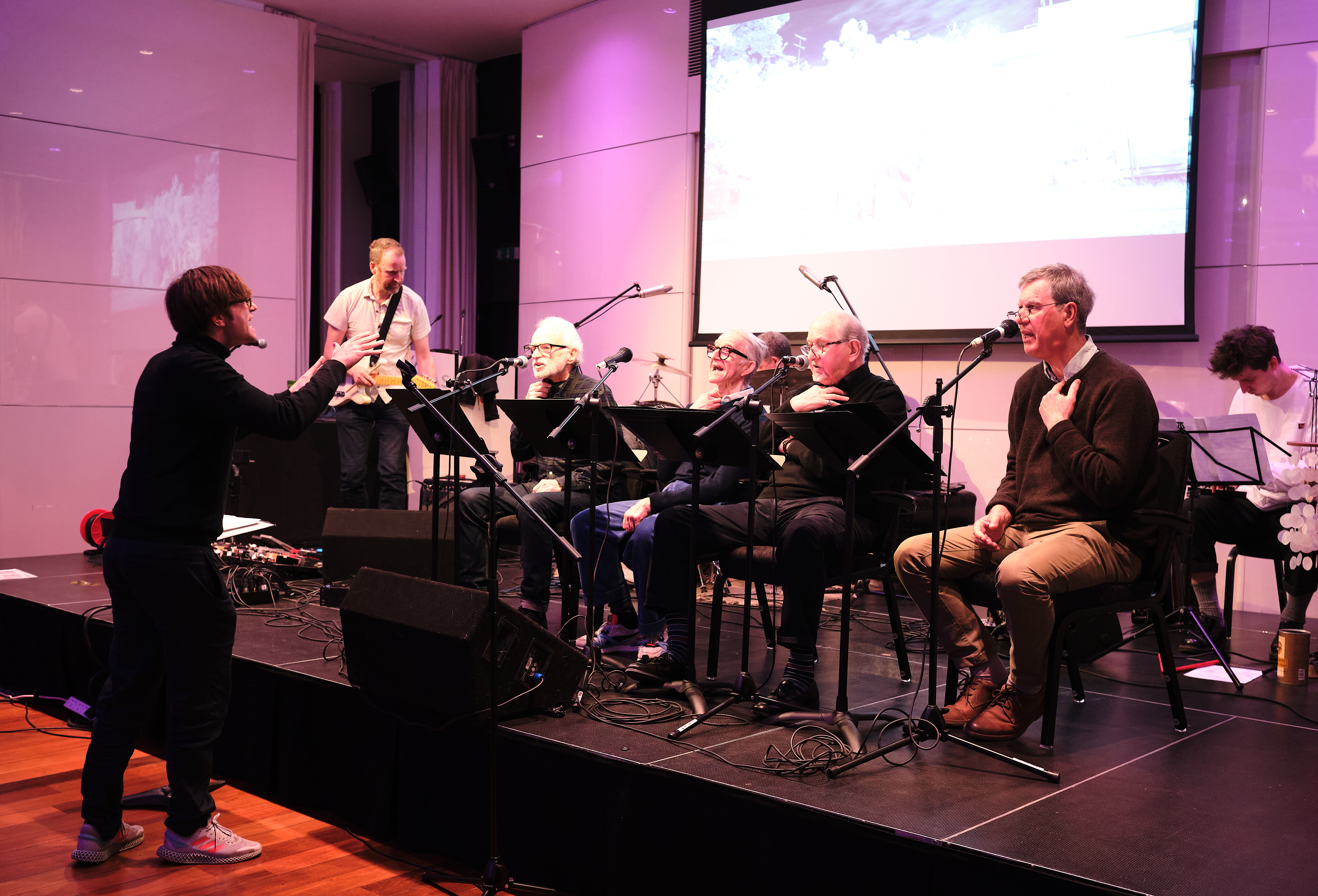 Thomas conducting, in the background from left to right: Philip, Donal, Spyridon, Ian Bradshaw, Andrew Pett, Christian Drew, during rehearsal at the Royal Over-Seas League, London