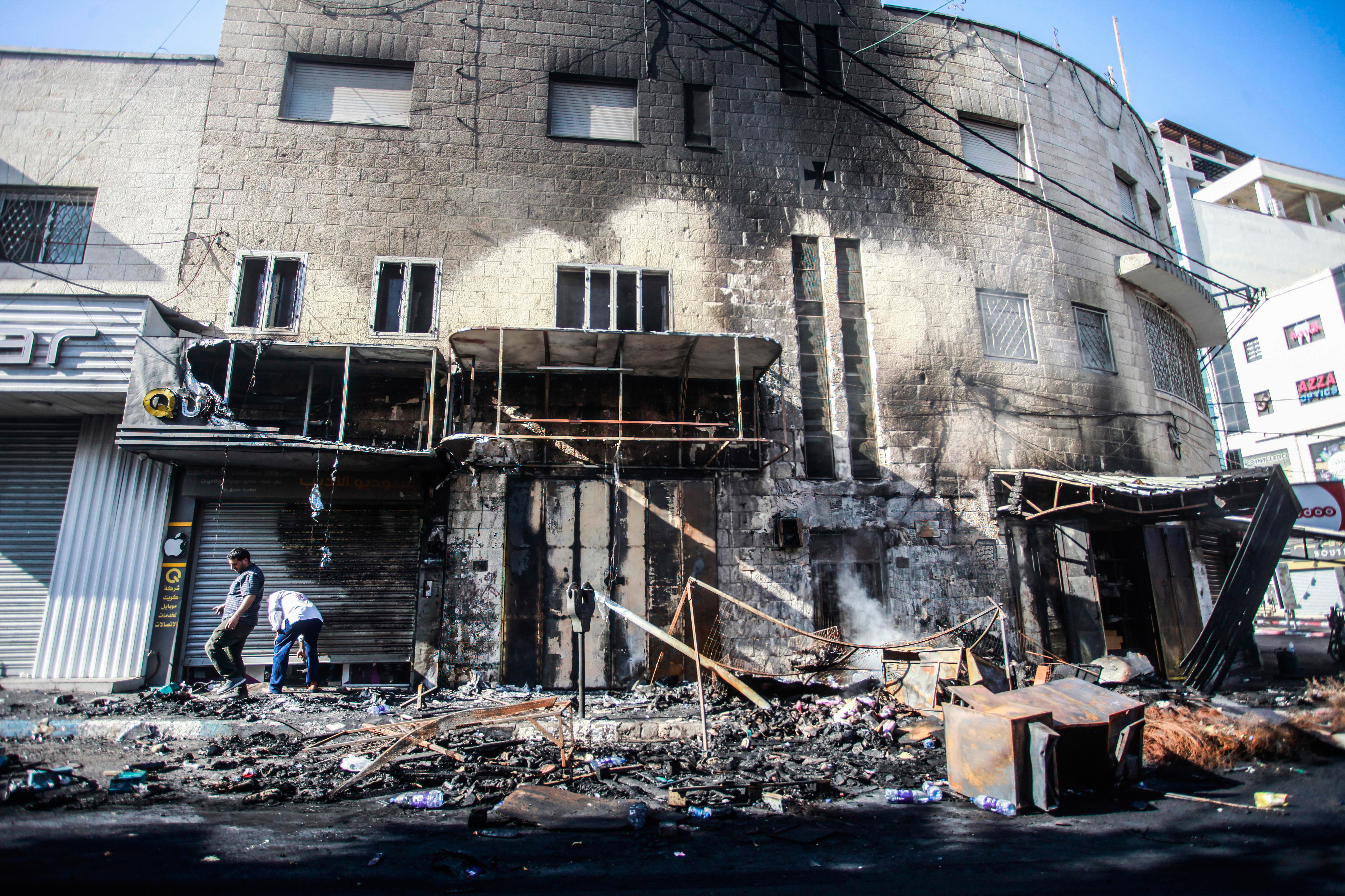JENIN, PALESTINE - 2023/07/04: Palestinians inspect shops burnt and destroyed by Israeli forces in the middle of the Jenin refugee camp, during the storming of the camp near the city of Jenin, in the northern occupied West Bank. Palestinian health officials said at least 10 Palestinians were killed in Israeli raids and airstrikes. Army spokesman Rear Adm. Daniel Hagari said Israel launched the operation because some 50 attacks over the past year had emanated from Jenin. (Photo by Nasser Ishtayeh/SOPA Images/LightRocket via Getty Images)