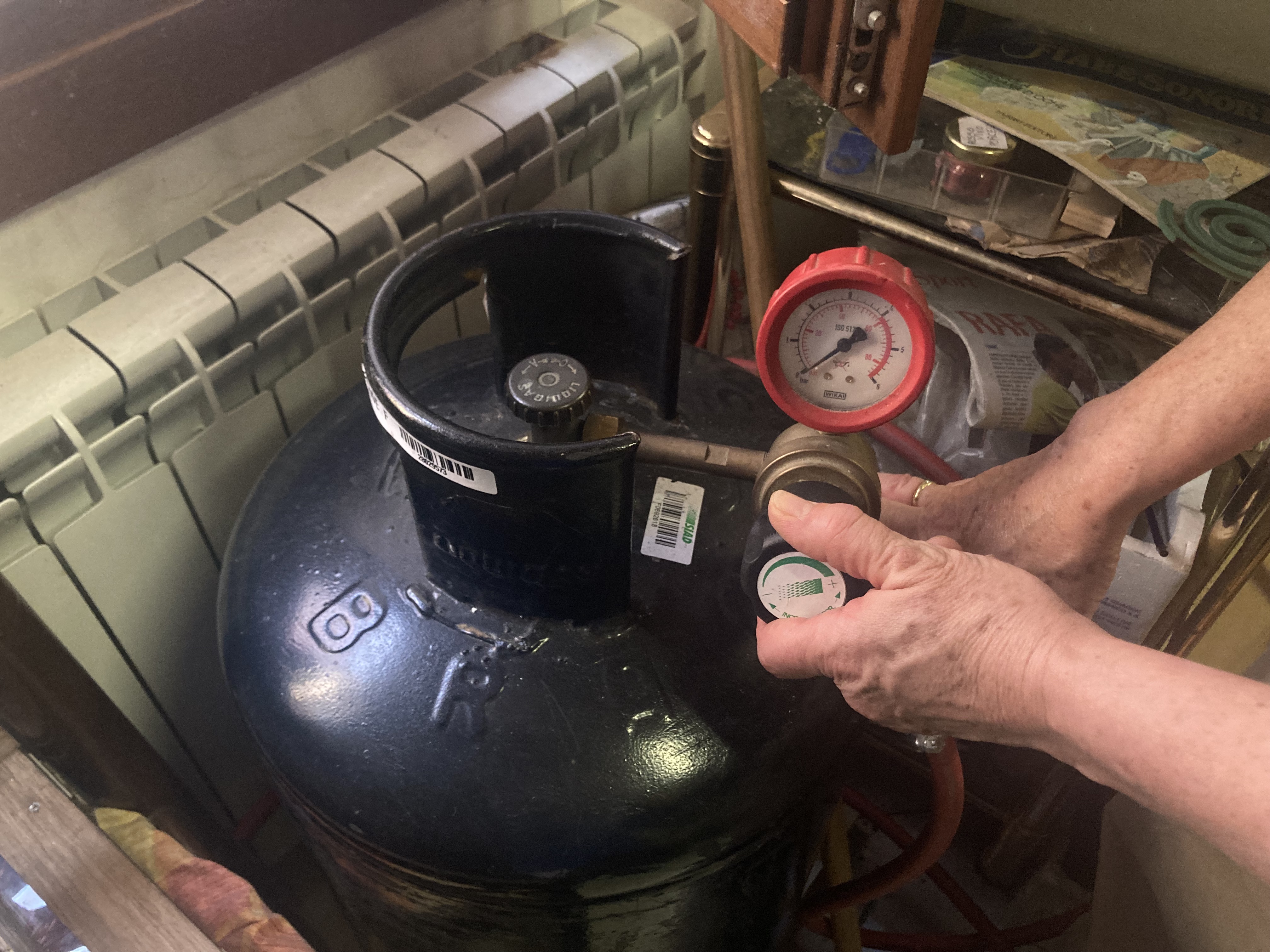 A glassblower turns on her propane tank 