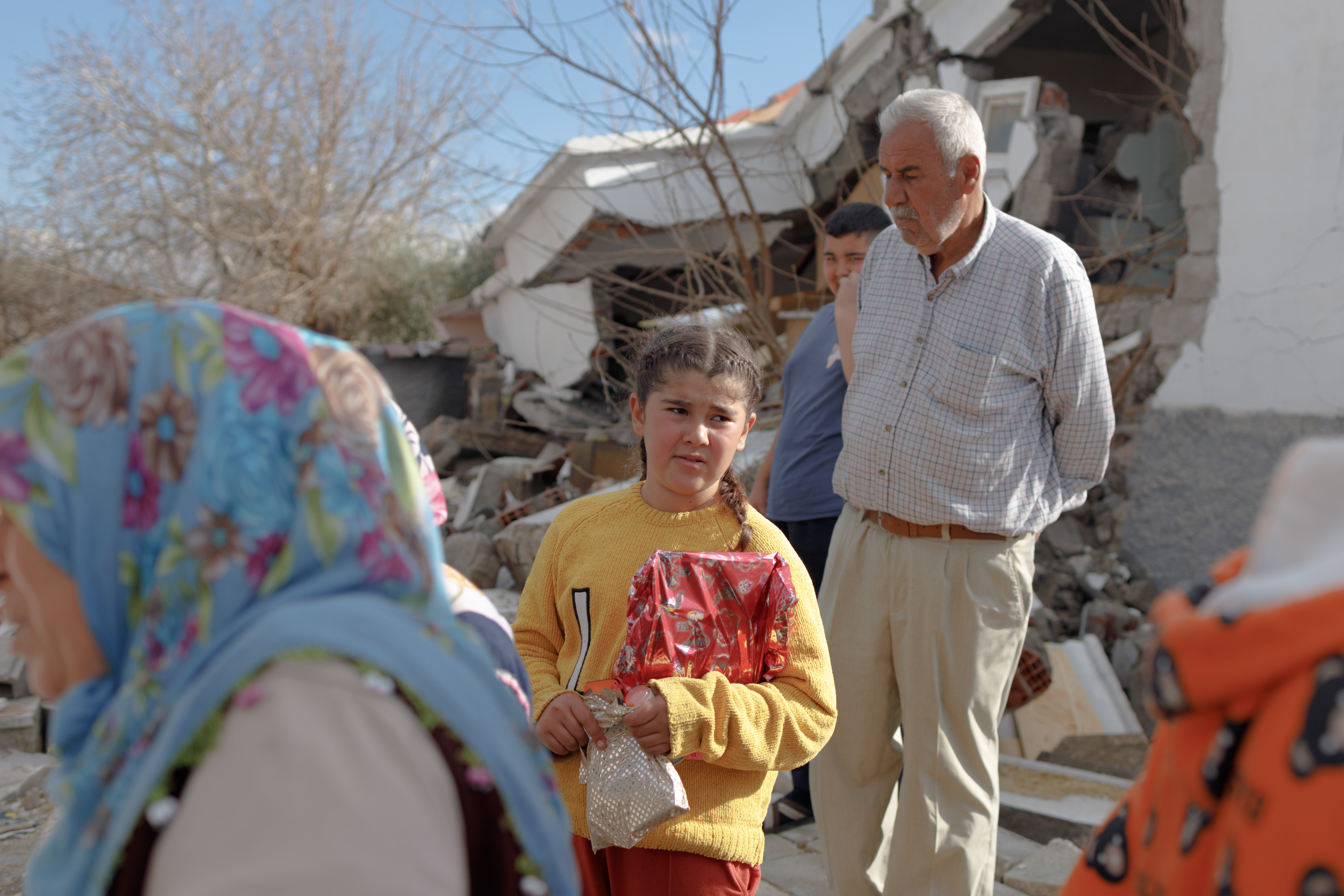 A girl collects gifts distributed by volunteers to families
