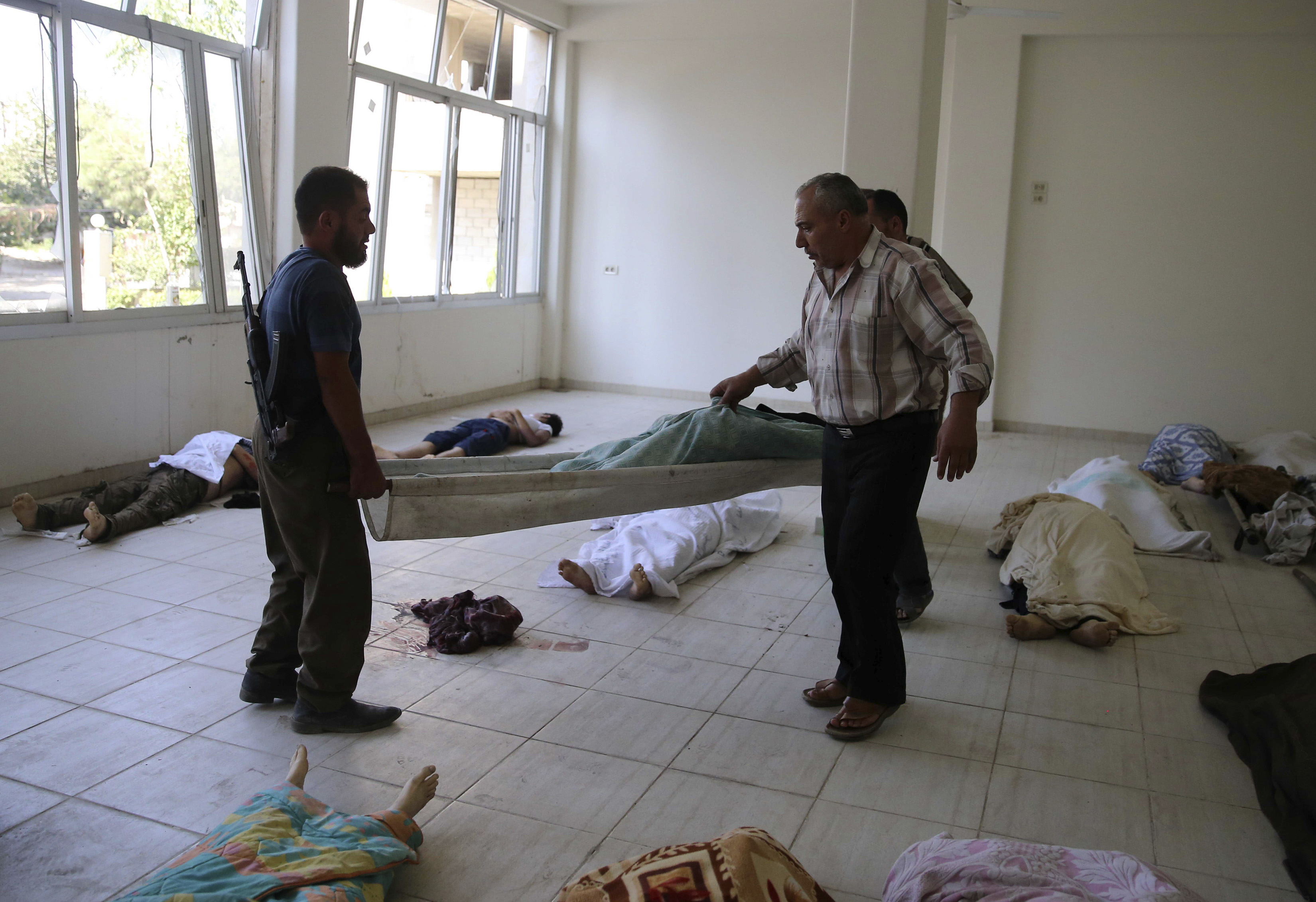ATTENTION EDITORS - VISUALS COVERAGE OF SCENES OF DEATH AND INJURY People carry the body of a civilian on a stretcher after what activists say were a gas attack in the Ghouta area, in the eastern suburbs of Damascus August 21, 2013. Syria's opposition accused President Bashar al-Assad's forces of gassing many hundreds of people - by one report as many as 1,300 - on Wednesday in what would, if confirmed, be the world's worst chemical weapons attack in decades. Western and regional countries called for U.N. chemical weapons investigators - who arrived in Damascus just three days ago - to be urgently dispatched to the scene of one of the deadliest incidents of the two-year-old civil war. REUTERS/Mohamed Abdullah (SYRIA - Tags: CONFLICT POLITICS CIVIL UNREST) TEMPLATE OUT