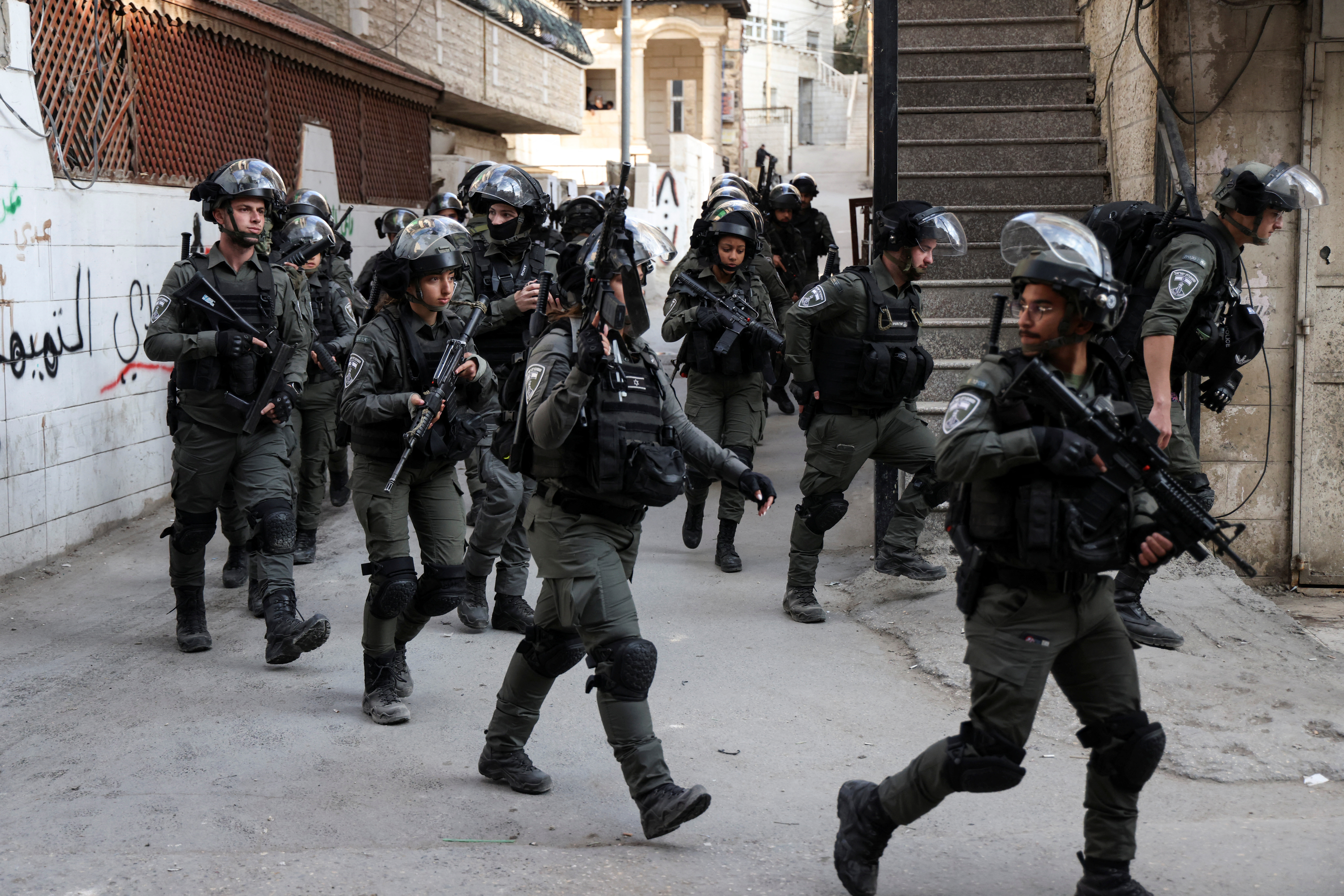 Israeli forces advance during clashes after Israeli forces destroy and seal off the family apartment of Uday Al-Tamimi, a Palestinian gunman accused of killing a soldier before he was himself shot dead, in the Shuafat refugee camp in East Jerusalem January 25, 2023. REUTERS/Ammar Awad