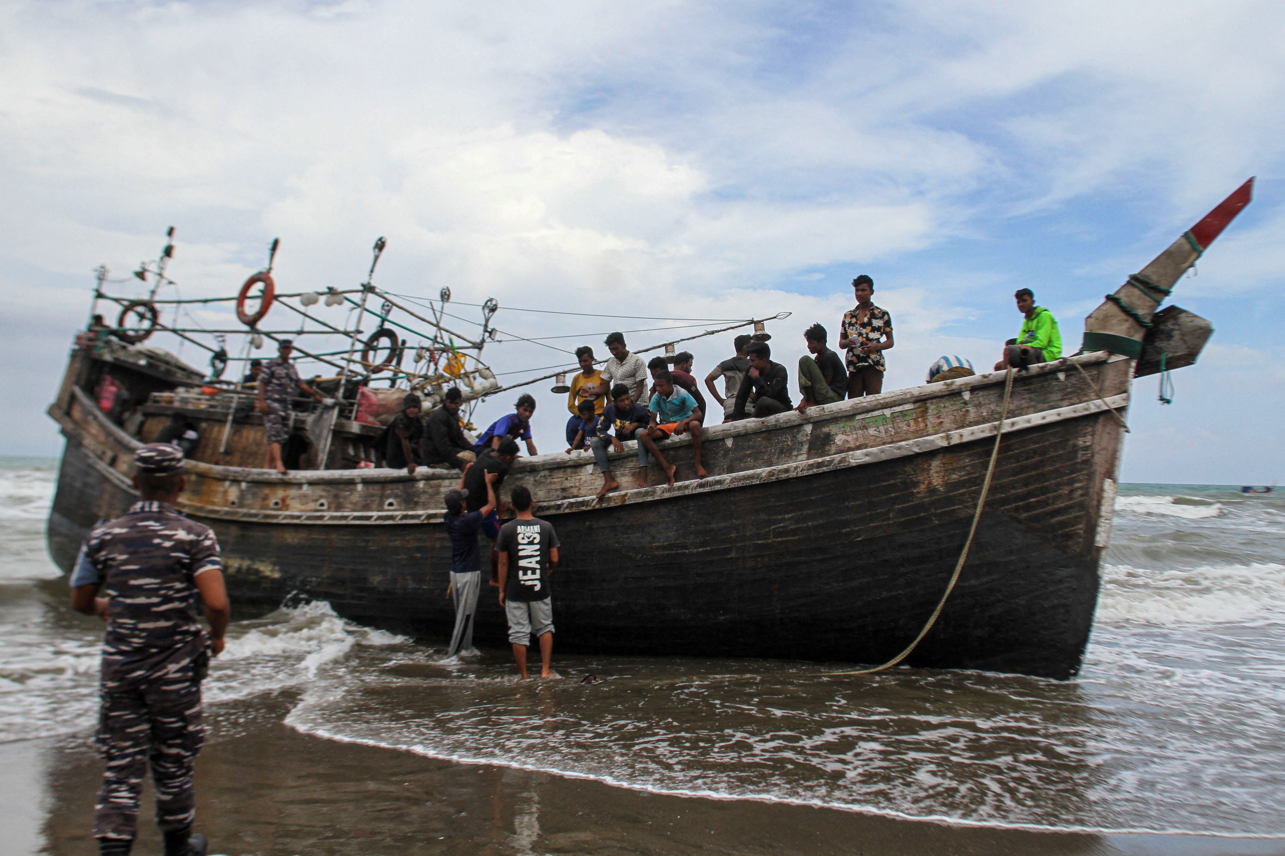 Indonesian Navy personnel guards the Rohingya Muslims as they arrive in Lampanah beach, Aceh province, Indonesia, February 16, 2023, in this photo taken by Antara Foto. Antara Foto/Ampelsa/via REUTERS ATTENTION EDITORS - THIS IMAGE HAS BEEN SUPPLIED BY A THIRD PARTY. MANDATORY CREDIT. INDONESIA OUT. NO COMMERCIAL OR EDITORIAL SALES IN INDONESIA.