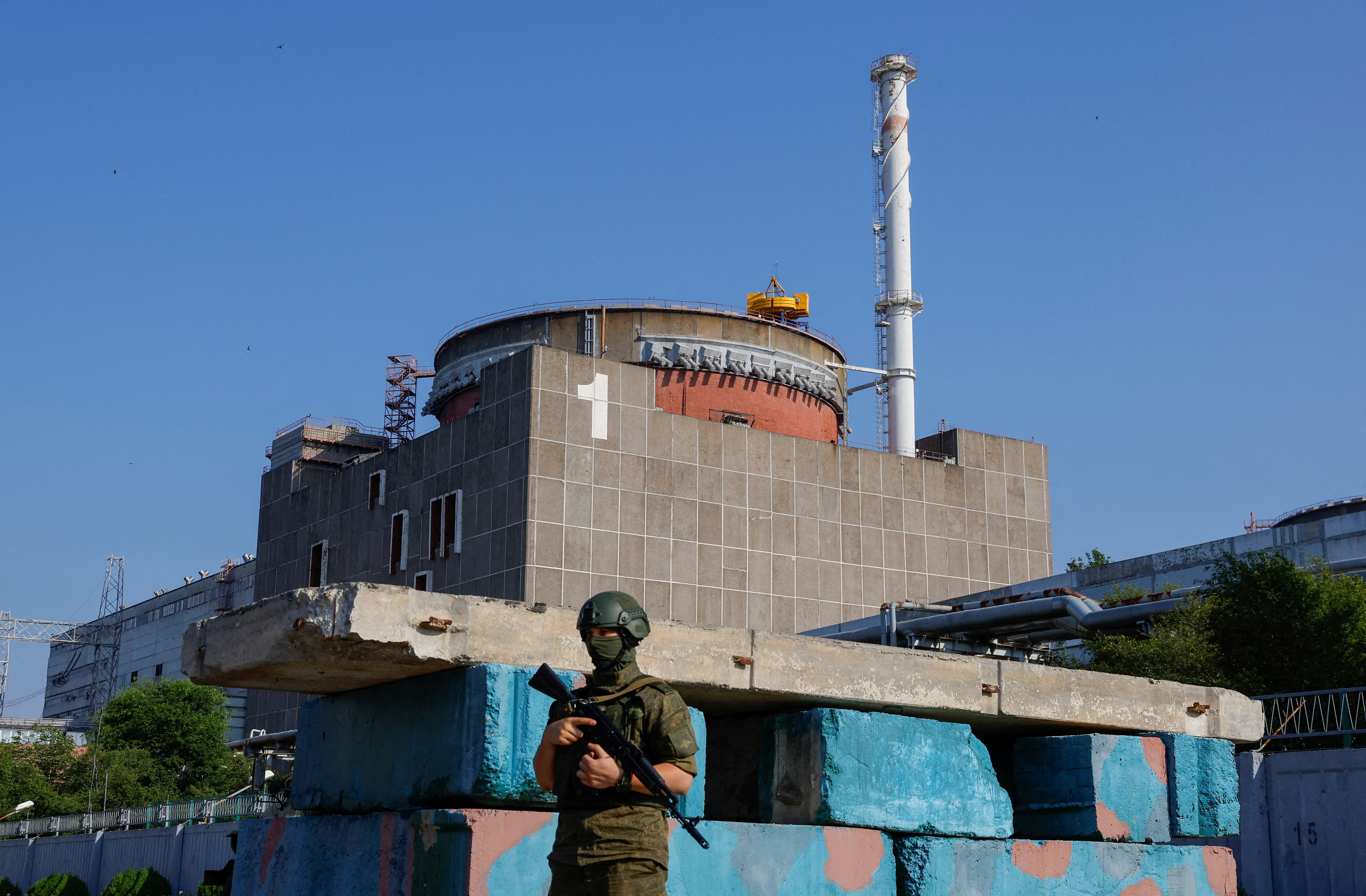 FILE PHOTO: A Russian service member stands guard at a checkpoint near the Zaporizhzhia Nuclear Power Plant before the arrival of the International Atomic Energy Agency (IAEA) expert mission in the course of Russia-Ukraine conflict outside Enerhodar in the Zaporizhzhia region, Russian-controlled Ukraine, June 15, 2023. REUTERS/Alexander Ermochenko/File Photo