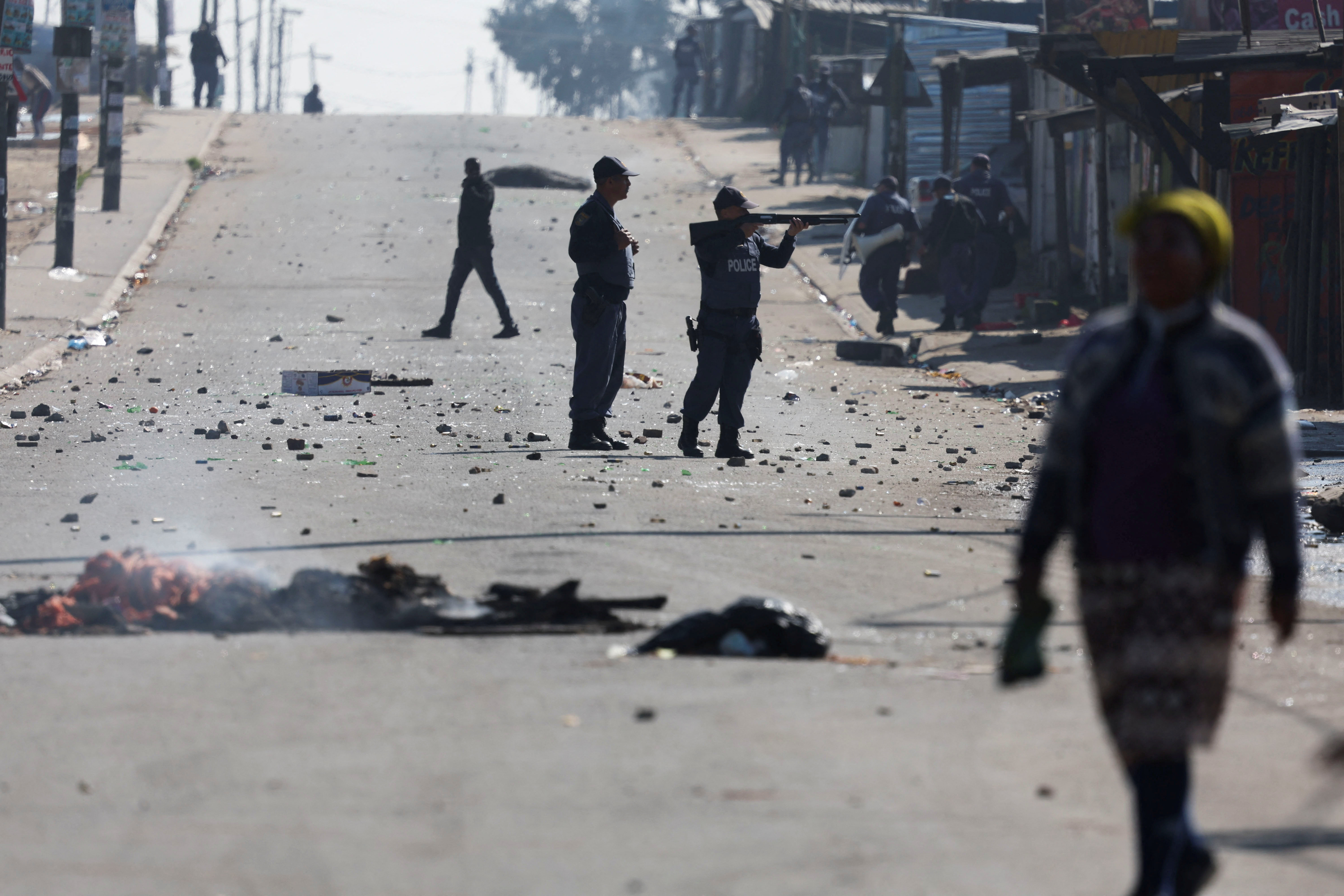 South African police officer takes aim at protesters during the ongoing strike by taxi operators against traffic authorities in Cape Town, South Africa, August 7, 2023 REUTERS/Esa Alexander