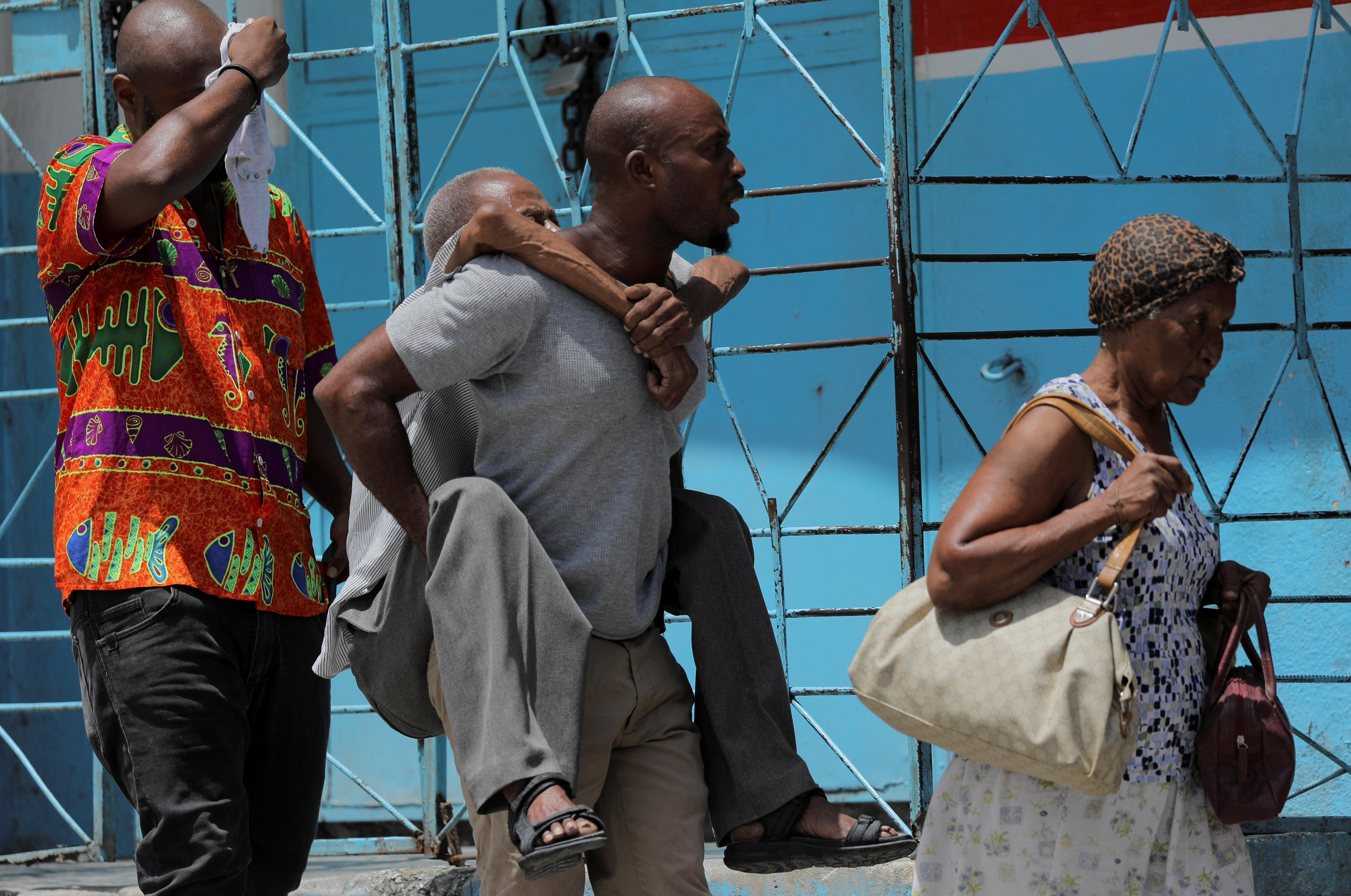 Displaced Haitians walk in a street after fleeing their homes in Port-au-Prince