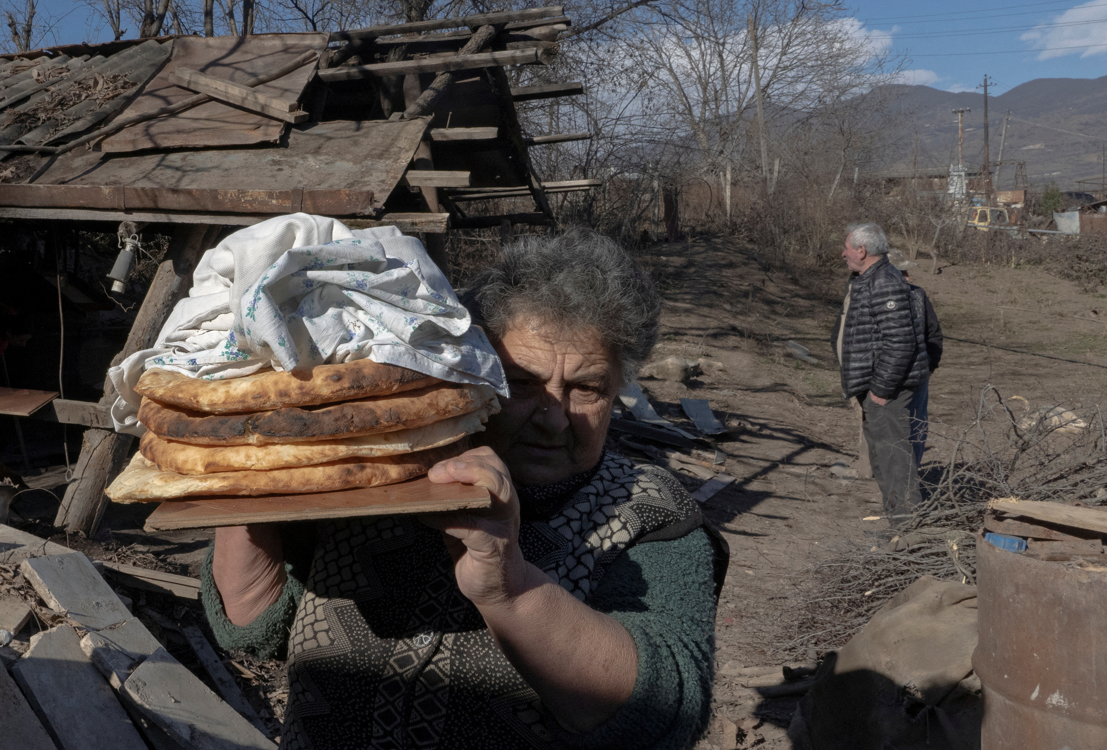 FILE PHOTO: Local resident Zina Fatyan carries freshly baked bread in the village of Taghavard in the region of Nagorno-Karabakh, January 15, 2021. Picture taken January 15, 2021. REUTERS/Artem Mikryukov/File Photo