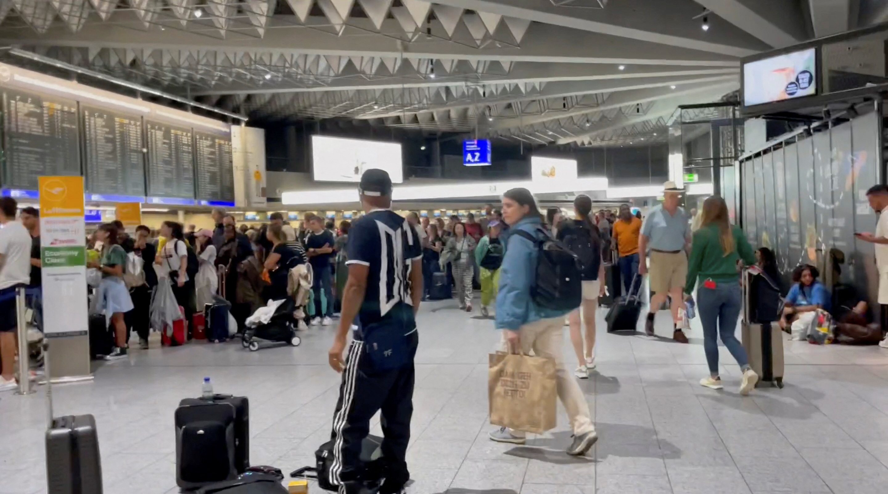 People gather at the airport as flights are cancelled or delayed due to floods, in Frankfurt, Germany