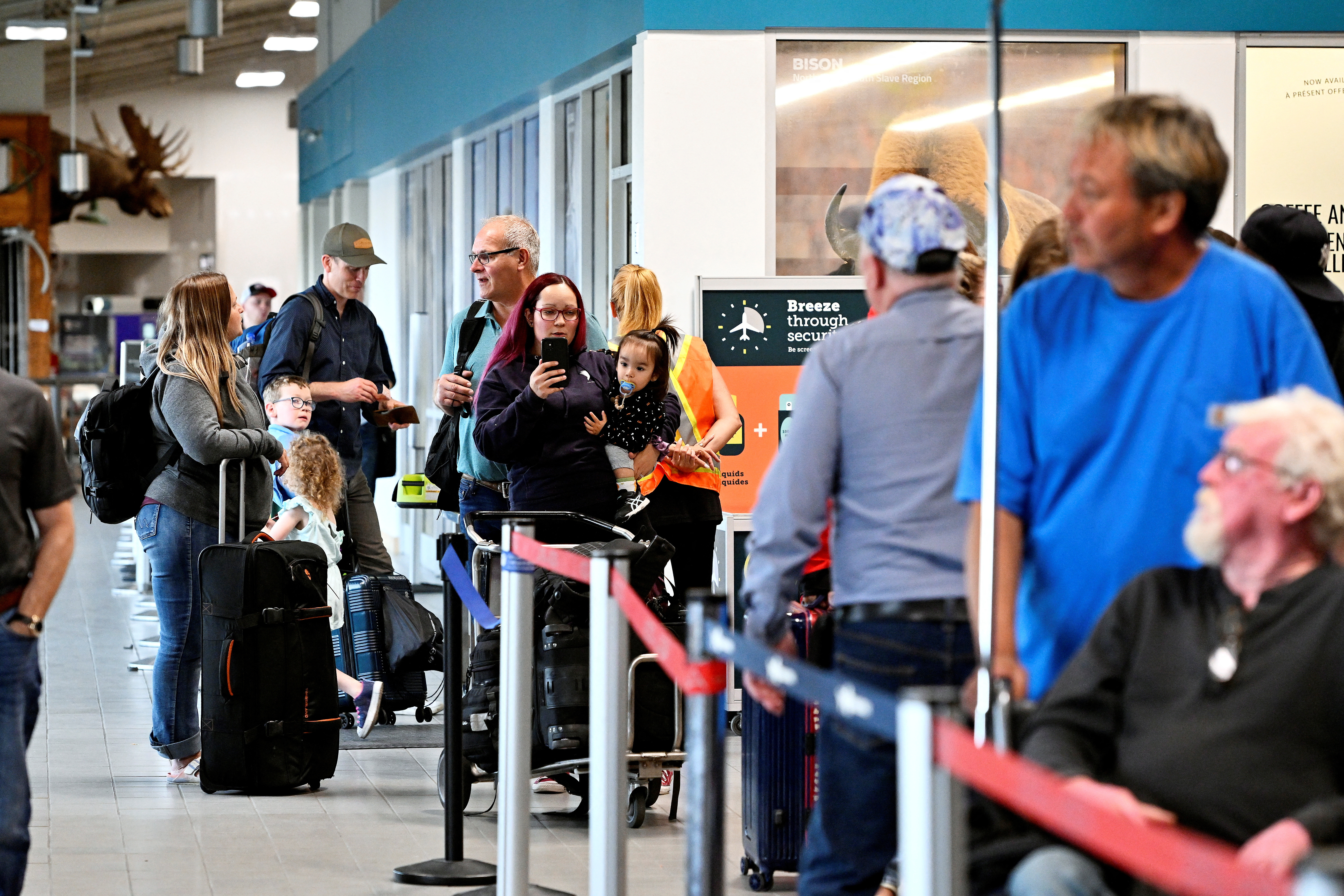 People wait in line at the airport in Yellowknife, Canada