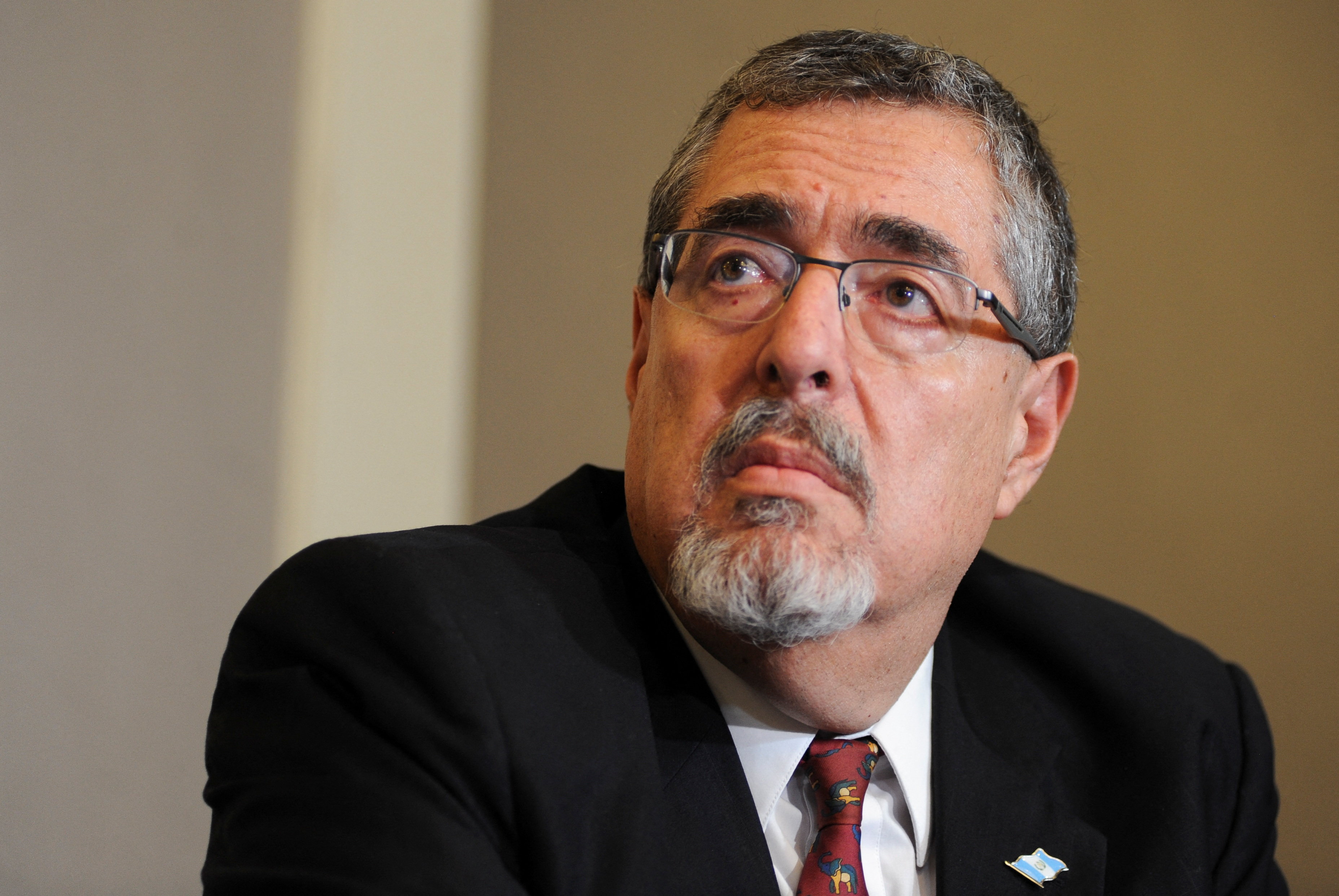 A close-up of Bernardo Arevalo, a man with glasses, a suit and a red tie.