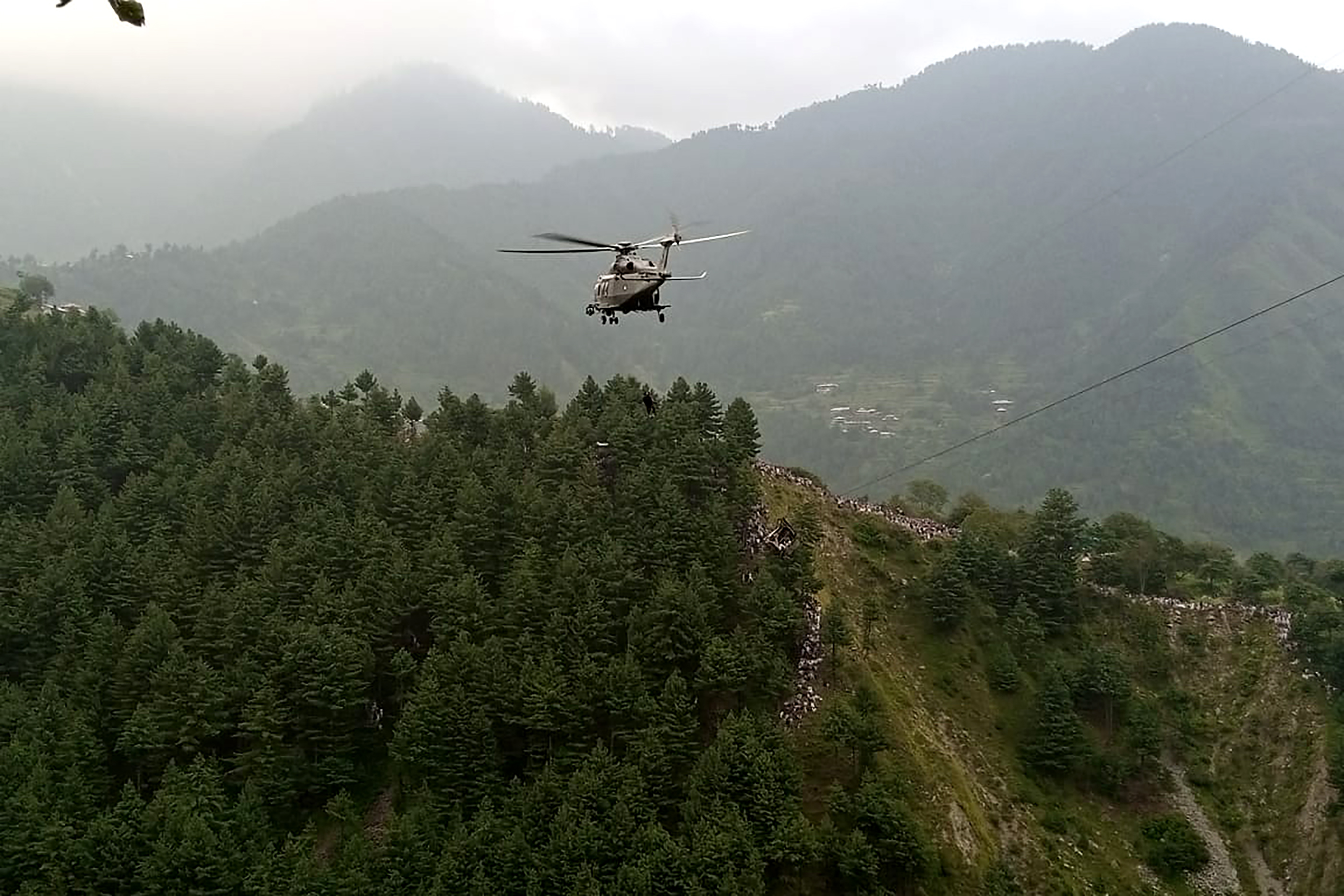 A military helicopter conducts a rescue operation to recover students stuck in a chairlift in the Pashto village of mountainous Khyber Pakhtunkhwa province