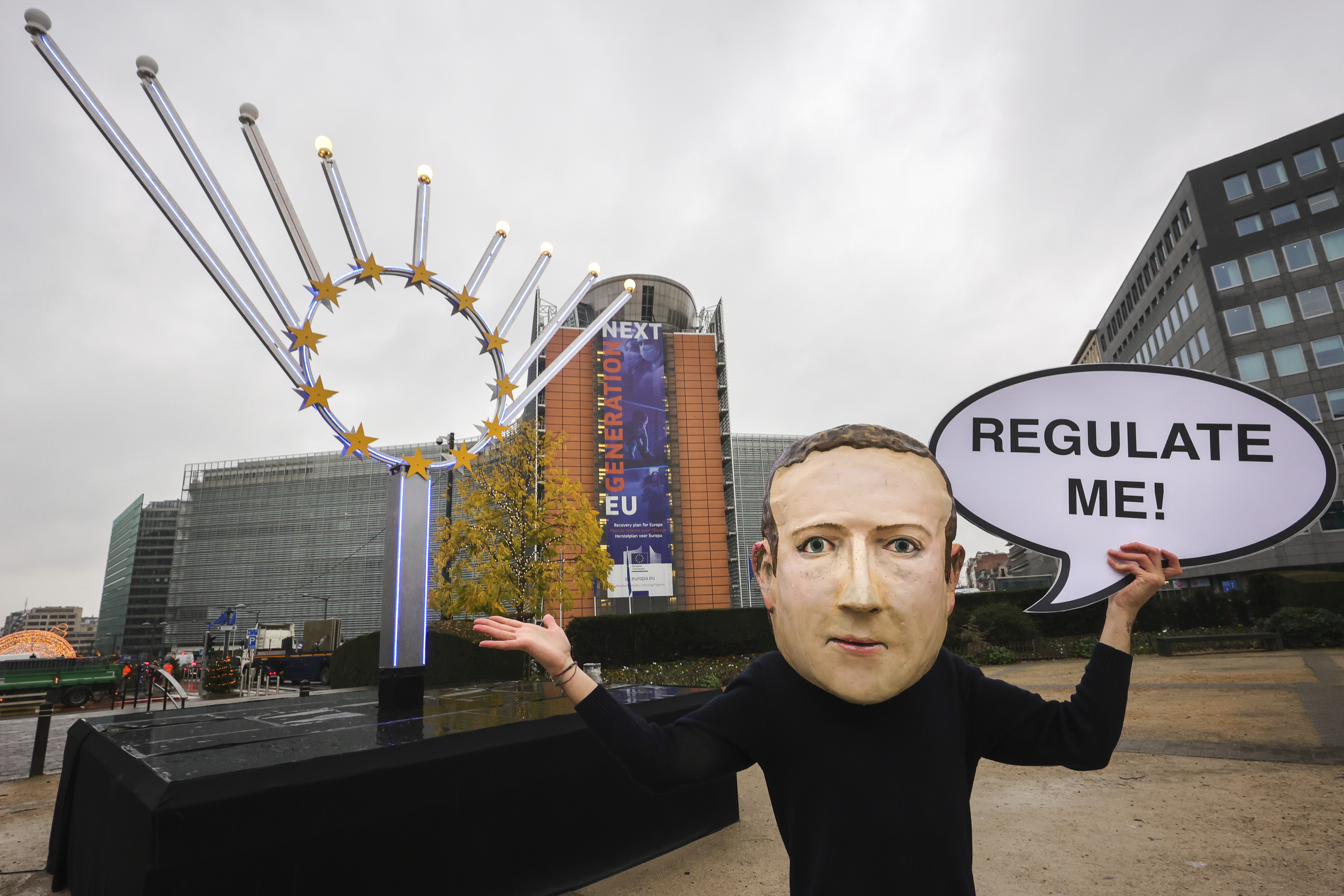 IMAGE DISTRIBUTED FOR AVAAZ - A campaigner from the global citizens movement Avaaz wearing a mask of Facebook CEO Mark Zuckerberg holds a sign reading "Regulate me", outside the European Commission on the day the Digital Services Act is published